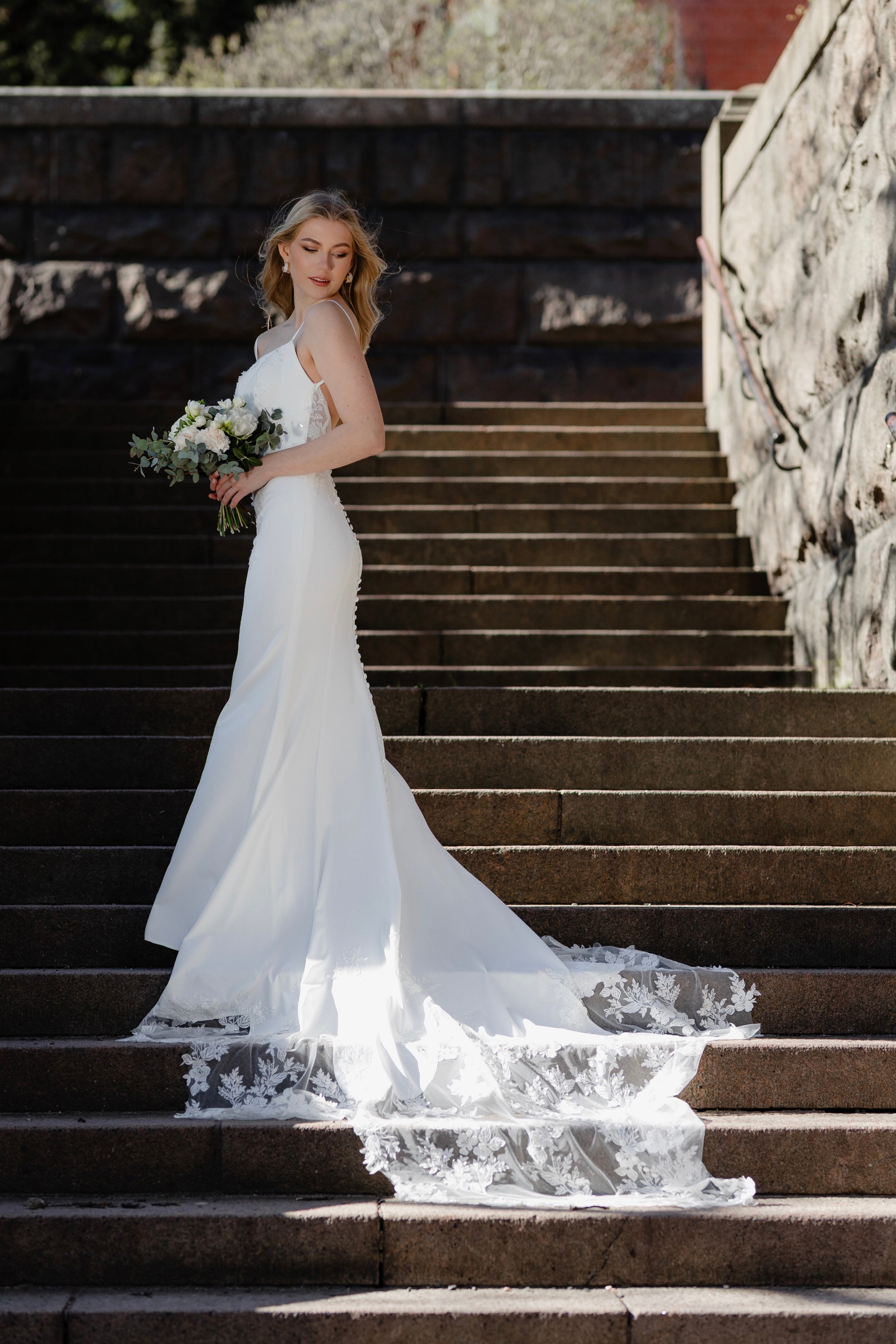 Häämekko ohutolkaimisella yläosalla, kukkabrodeerauksilla ja pitkällä laahuksella. takaa.