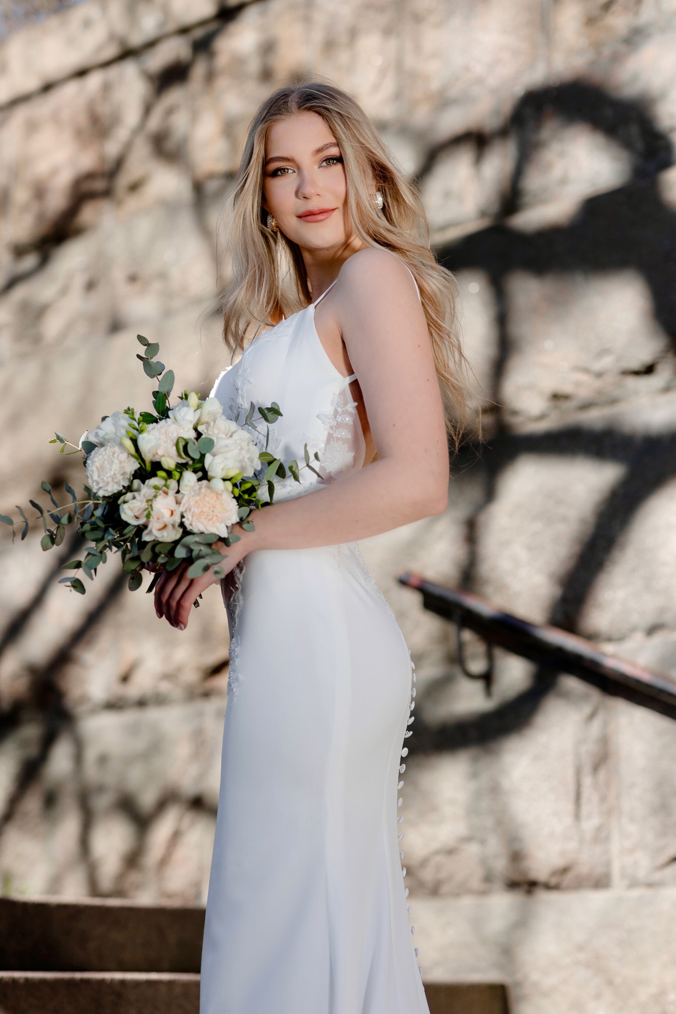 Häämekko ohutolkaimisella yläosalla, kukkabrodeerauksilla ja pitkällä laahuksella, sivusta.