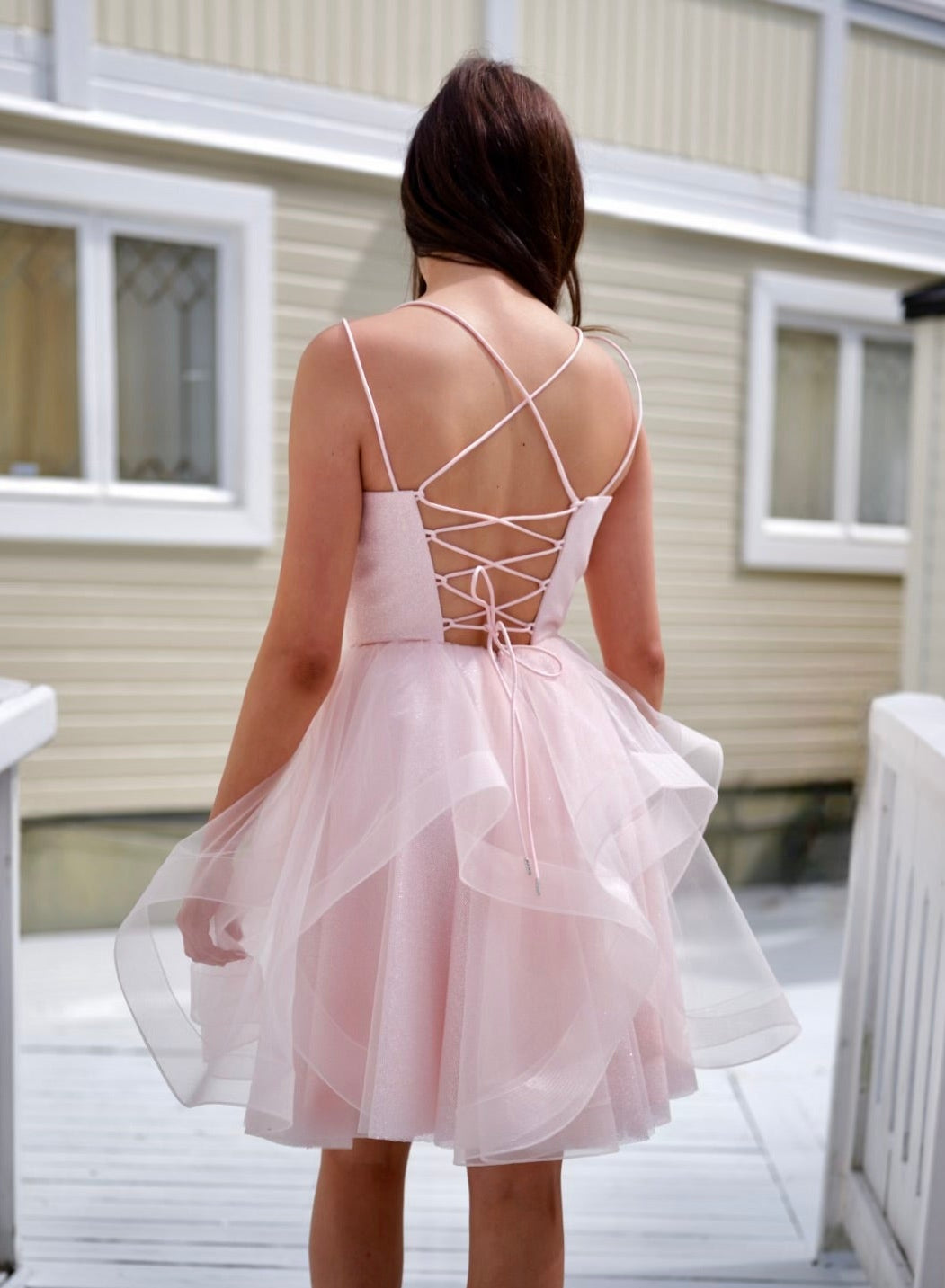 Näyttävä vaaleanpunainen juhlamekko kimaltavalla pinnalla.