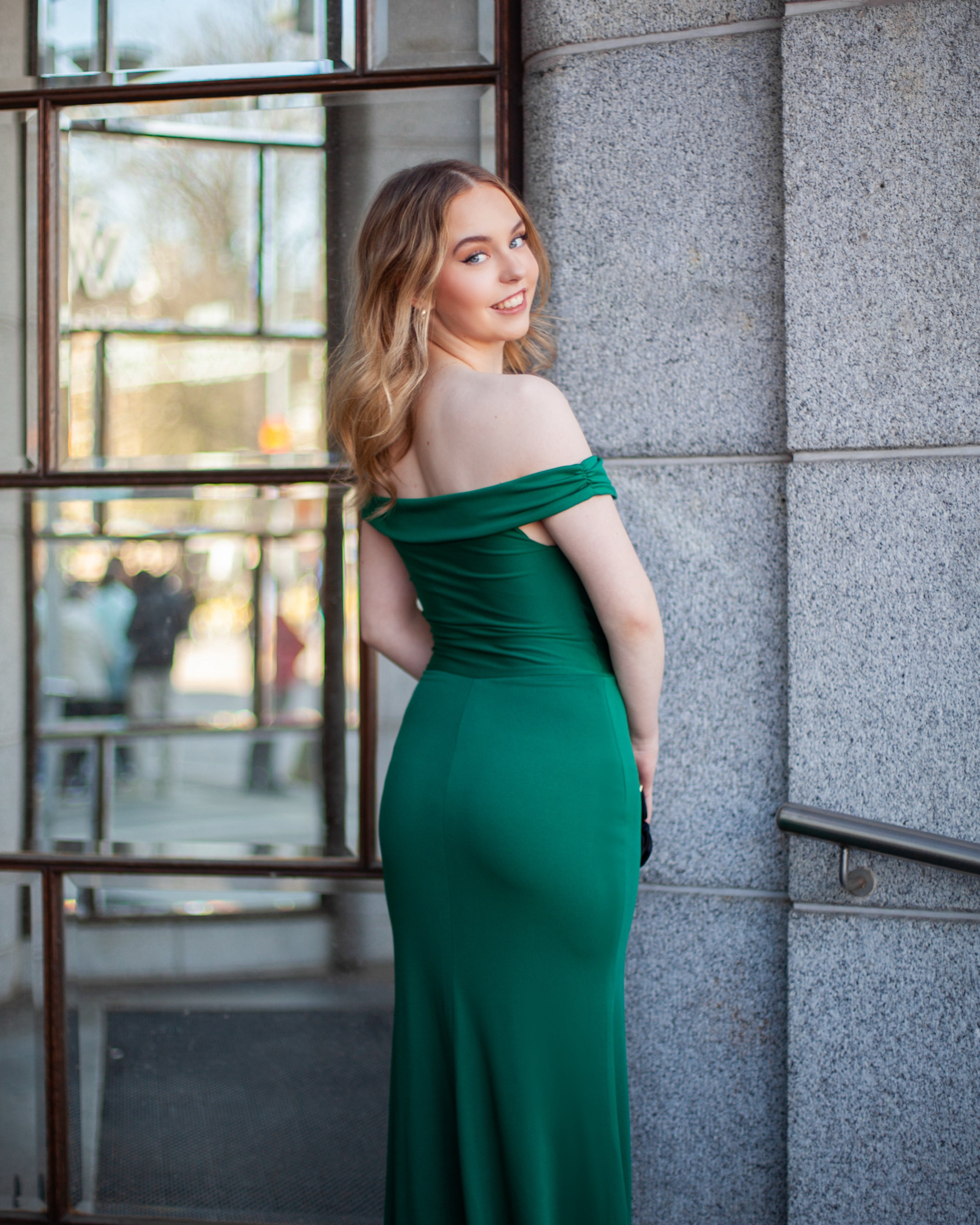 Vihreä off shoulder -iltapuku kauniisti laskeutuvalla helmalla, takaa.