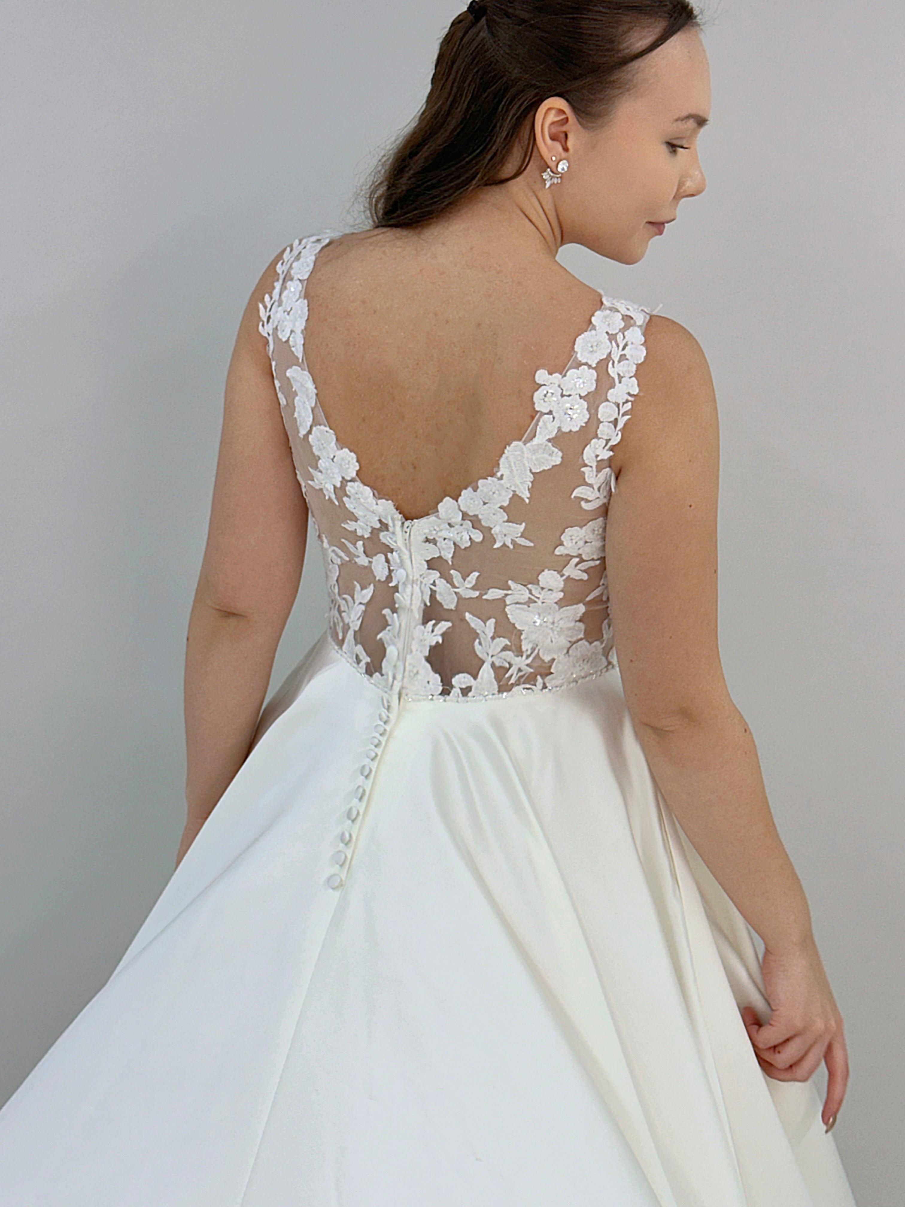 Häämekko peittävämpi malli pitsiyläosalla ja satiinihelma, takakuva.
