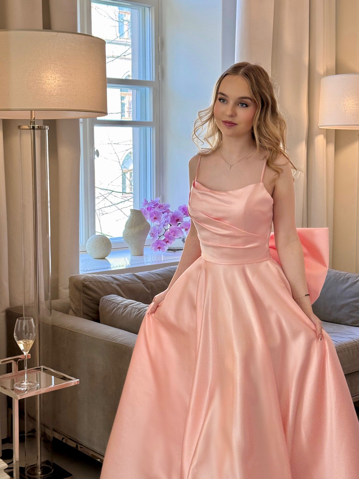 Vaaleanpunainen vanhojentanssimekko isolla rusetilla, etukuva.