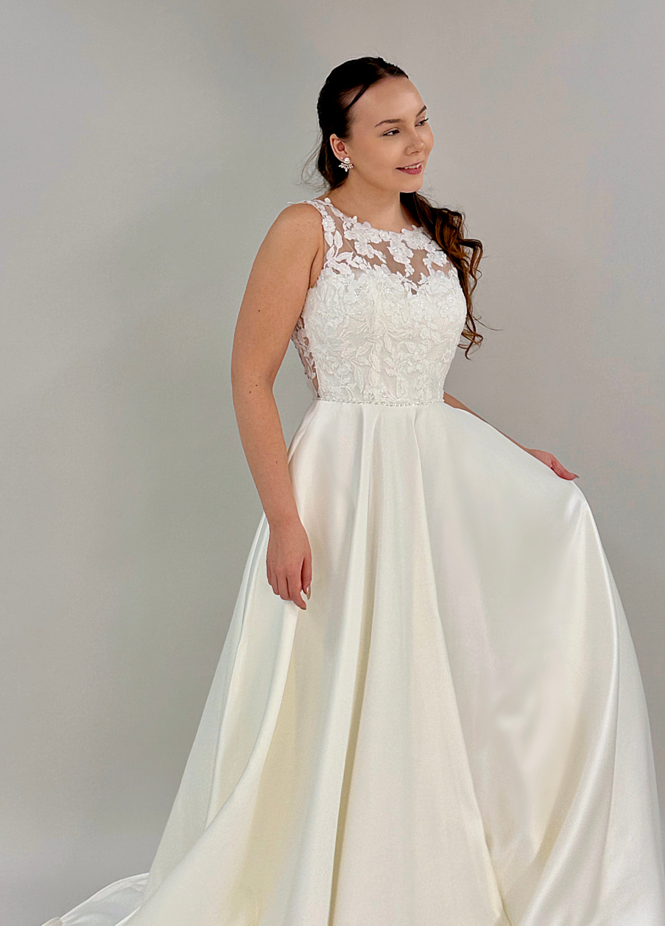 Häämekko peittävämpi malli pitsiyläosalla ja satiinihelma, edestä.