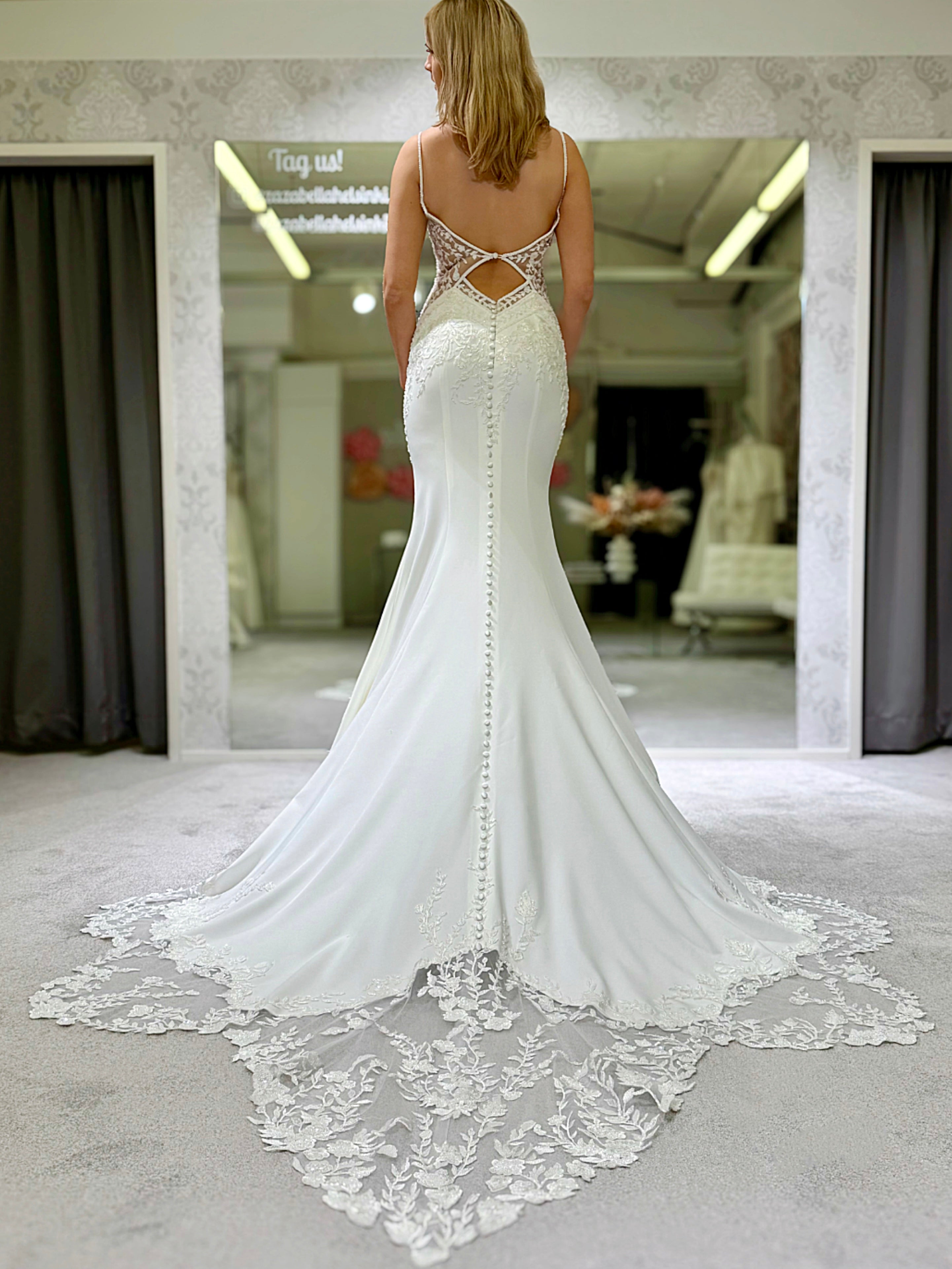 Häämekko, jossa pitkä laahus, pitsiyläosa ja kaunis selkäkoriste, takaa.