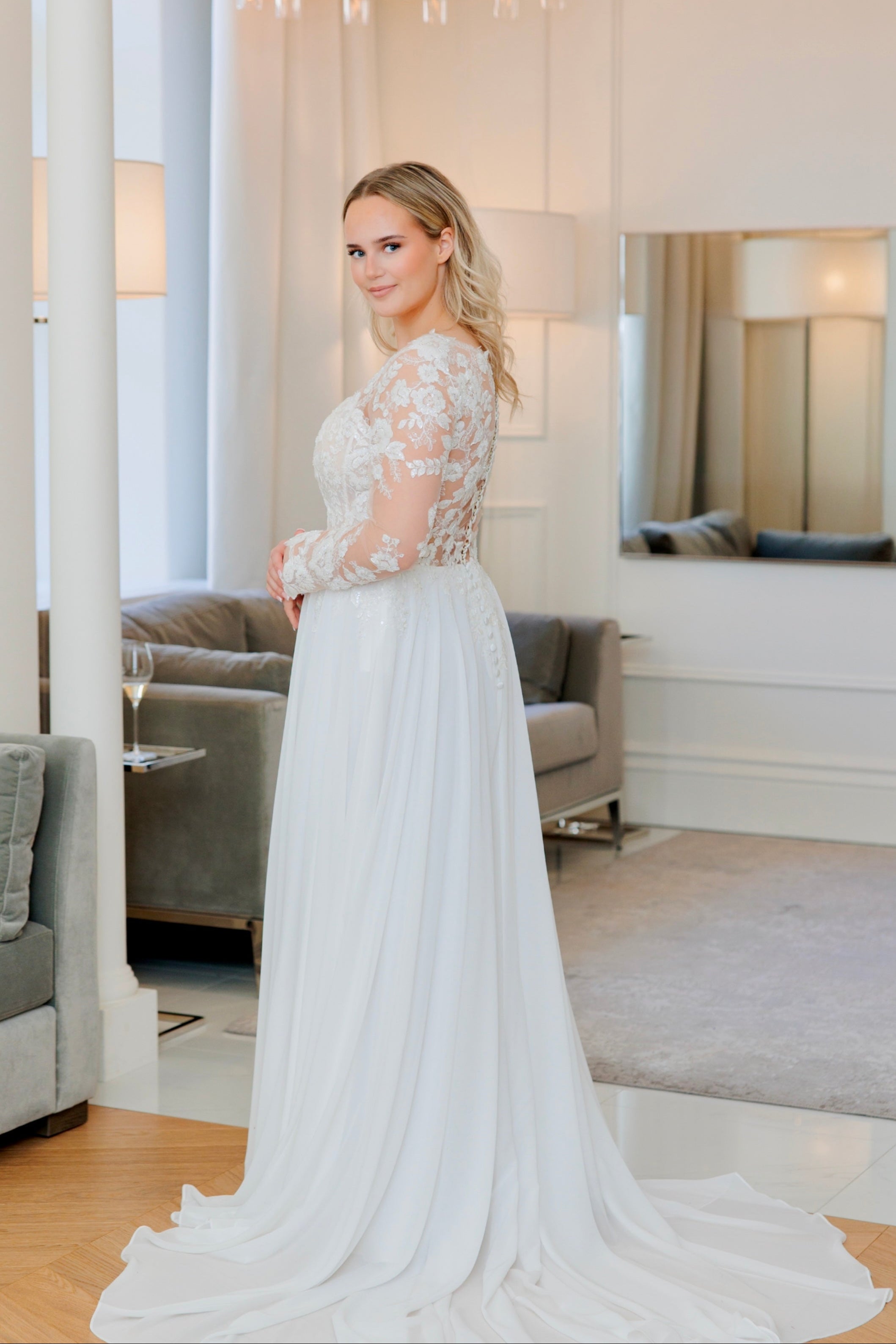 Häämekko pitsihihoilla, sifonkihelmalla ja kauniilla laahuksella.