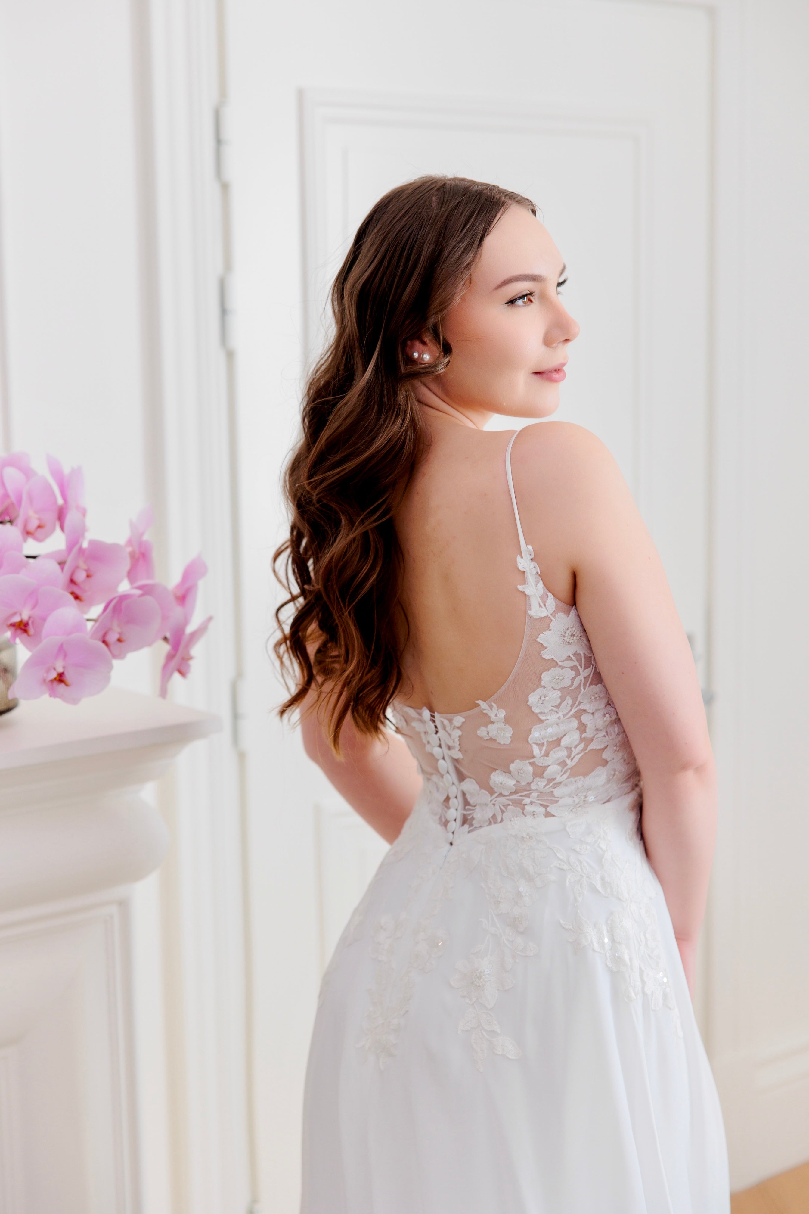 Häämekko sifongista, pitsiyksityiskohdilla ja näyttävällä laahuksella, takakuva.