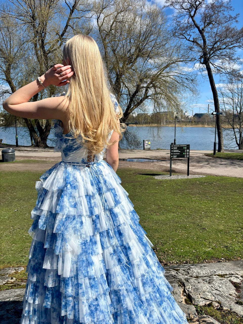 Valko‑sininen vanhojentanssimekko röyhelöhelmalla, selkä.