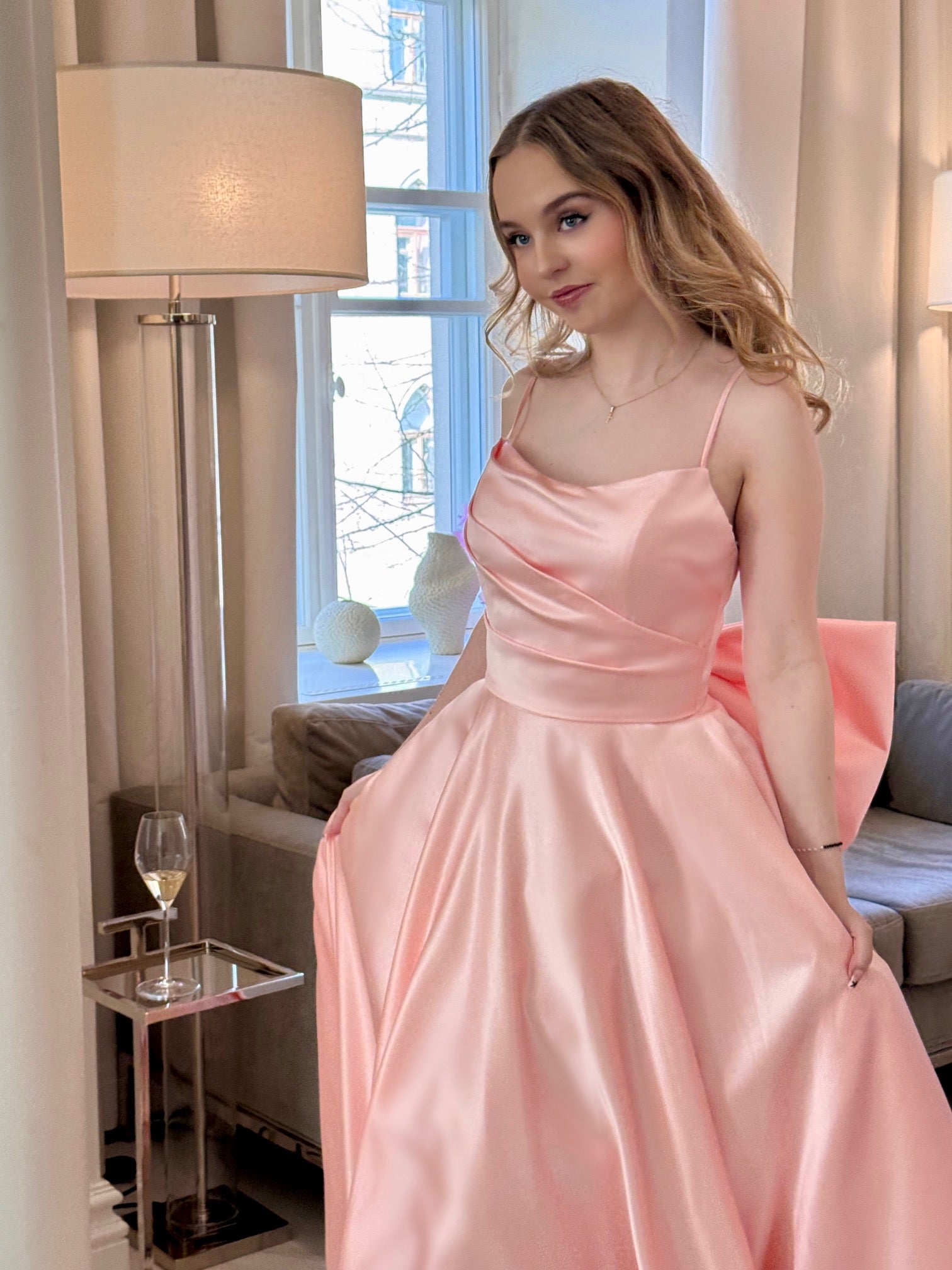 Vaaleanpunainen vanhojentanssimekko isolla rusetilla, etukuva.