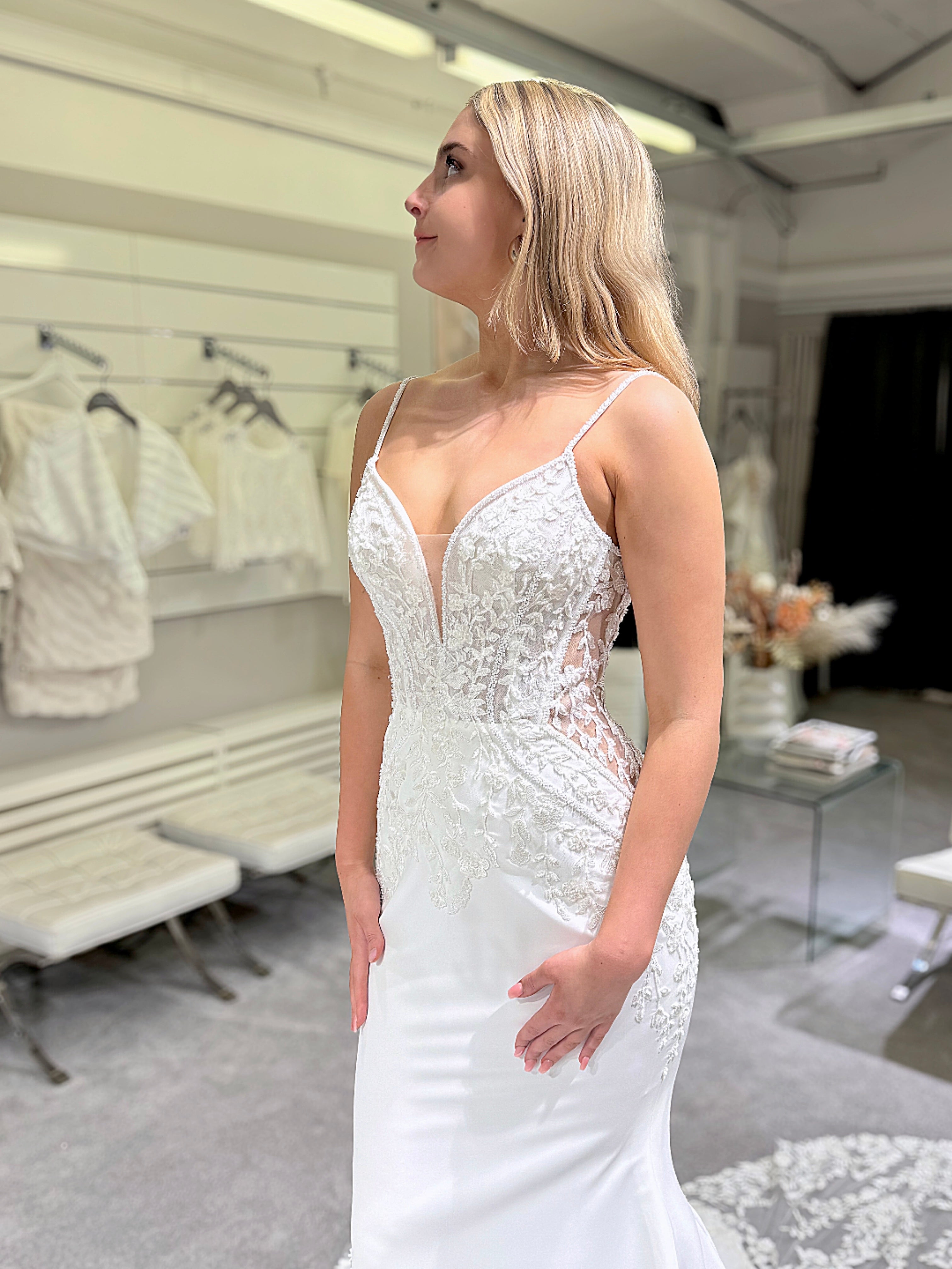 Häämekko, jossa pitkä laahus, pitsiyläosa ja kaunis selkäkoriste.