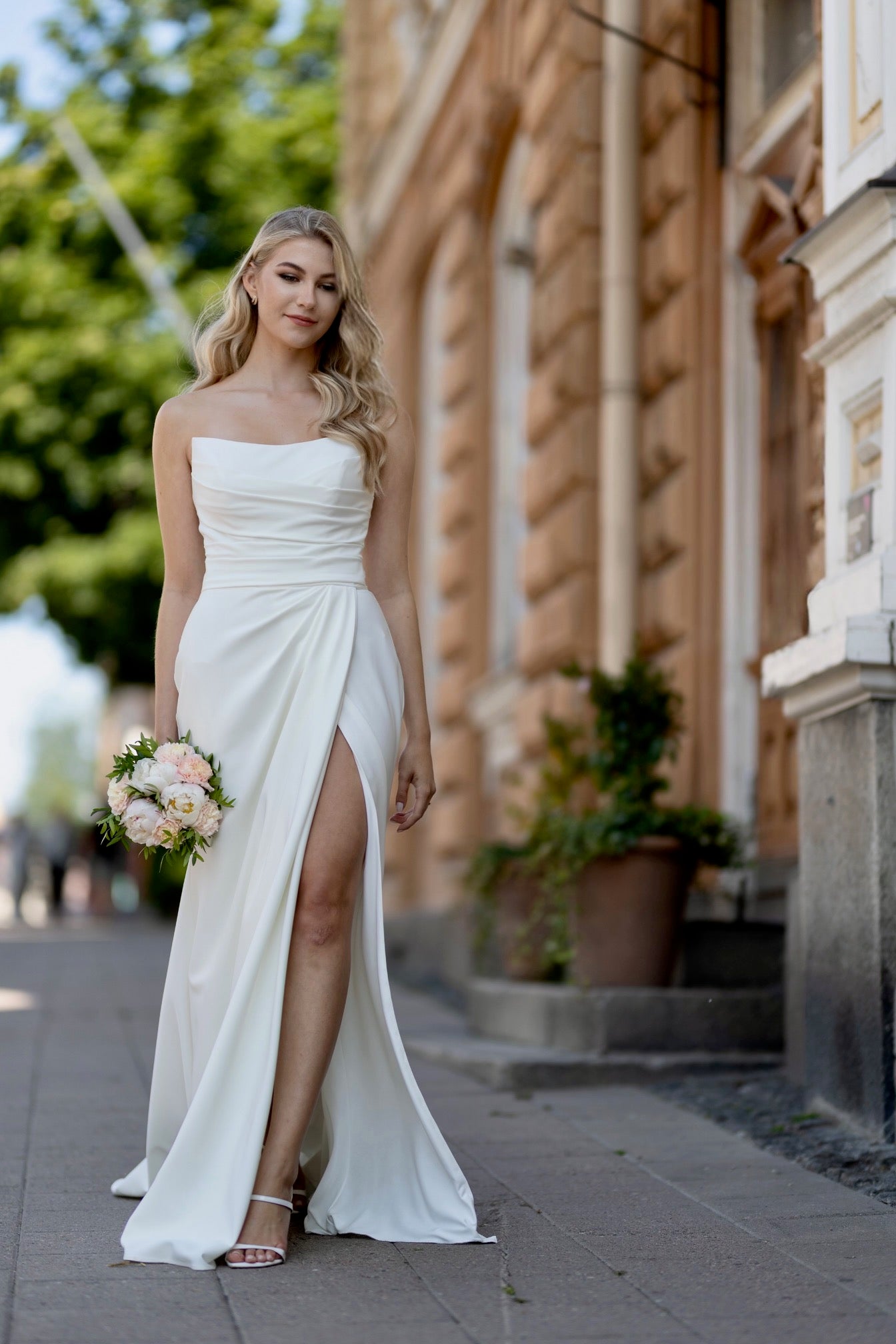 Olkaimeton tyköistuva häämekko halkiolla.