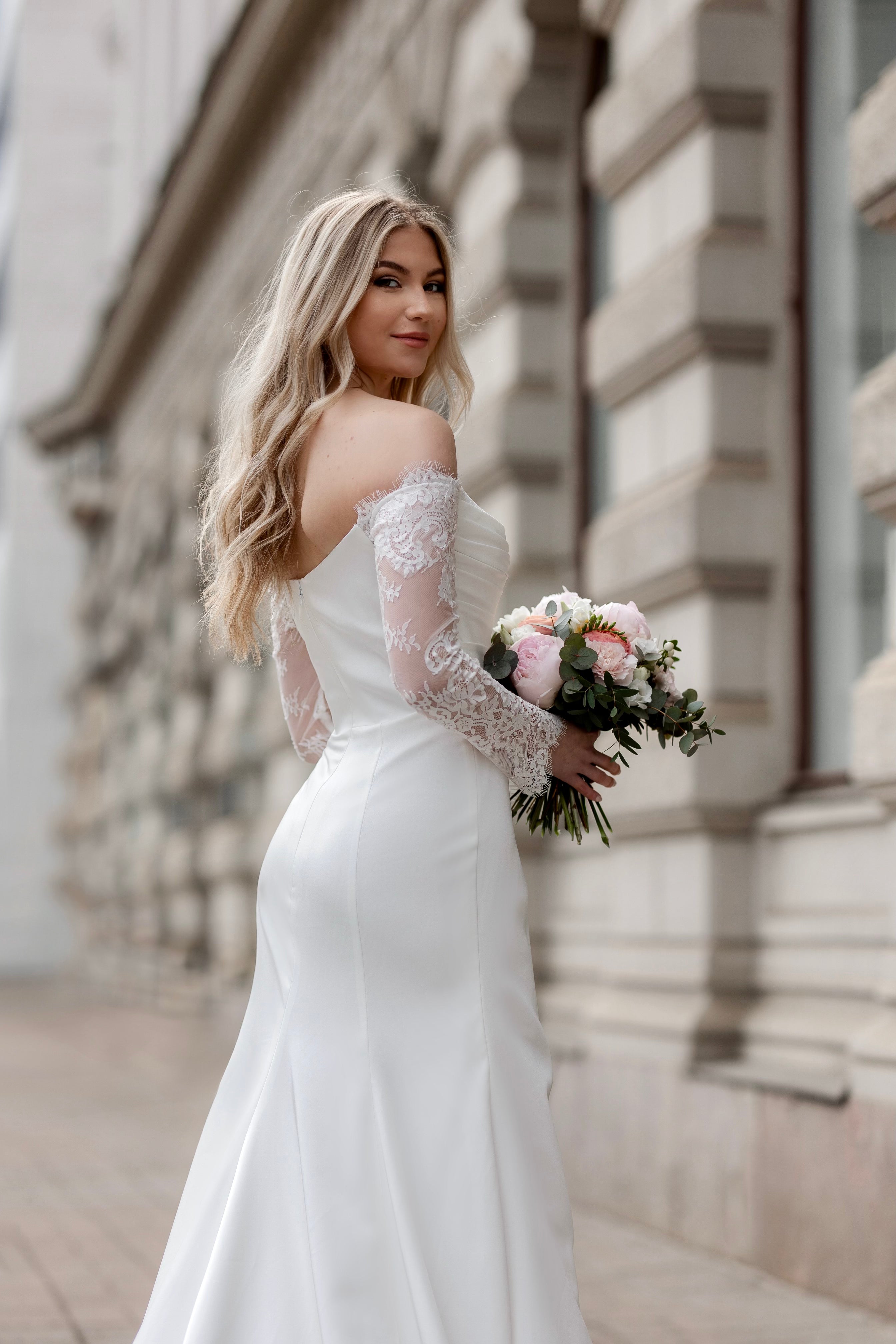 Häämekko Nina vartaloa myötäilevällä kankaalla, pitkä hiha ja sivuhalkio.