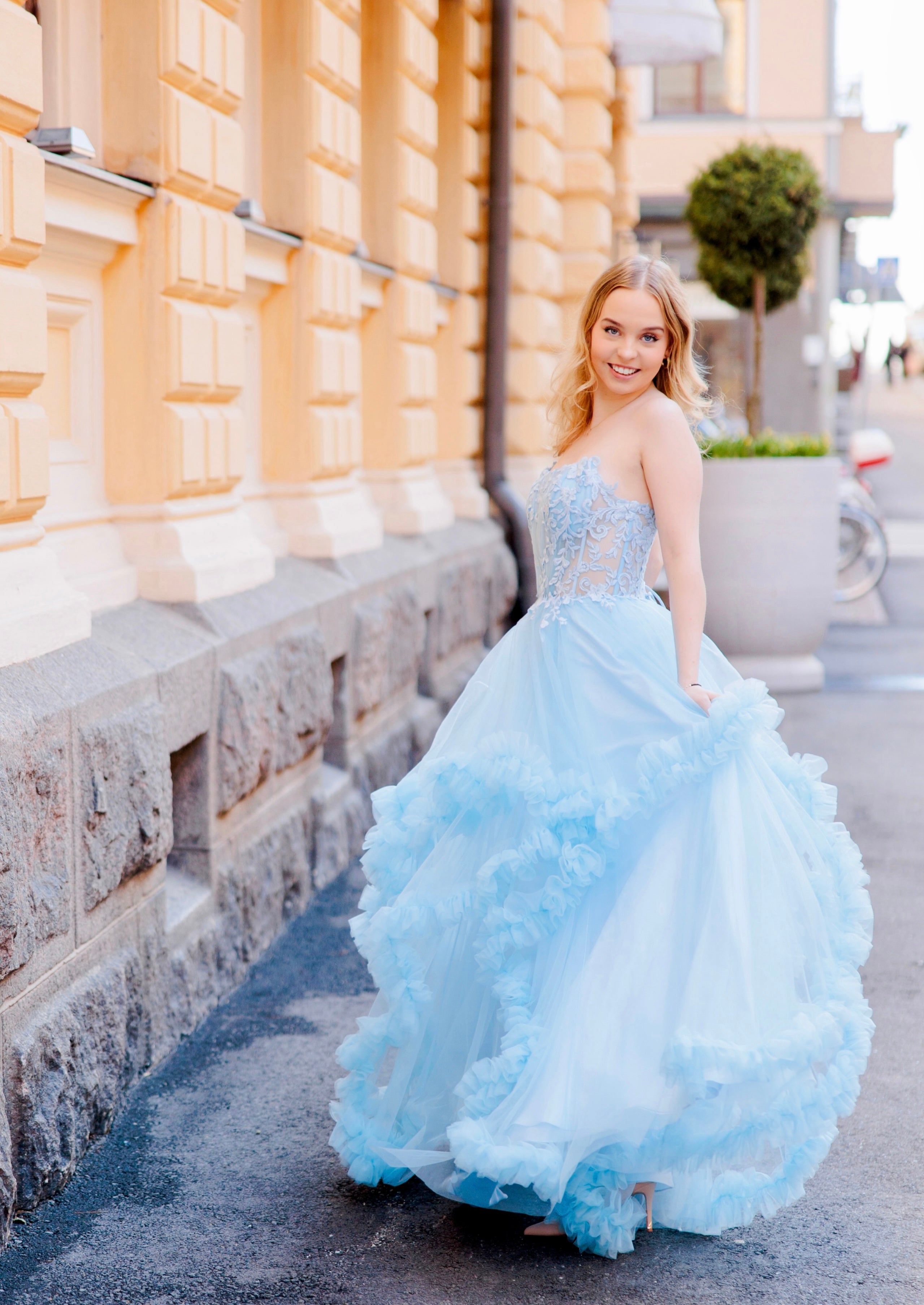 Olkaimeton vaaleansininen röyhelähelmainen vanhojentanssimekko, sivusta.