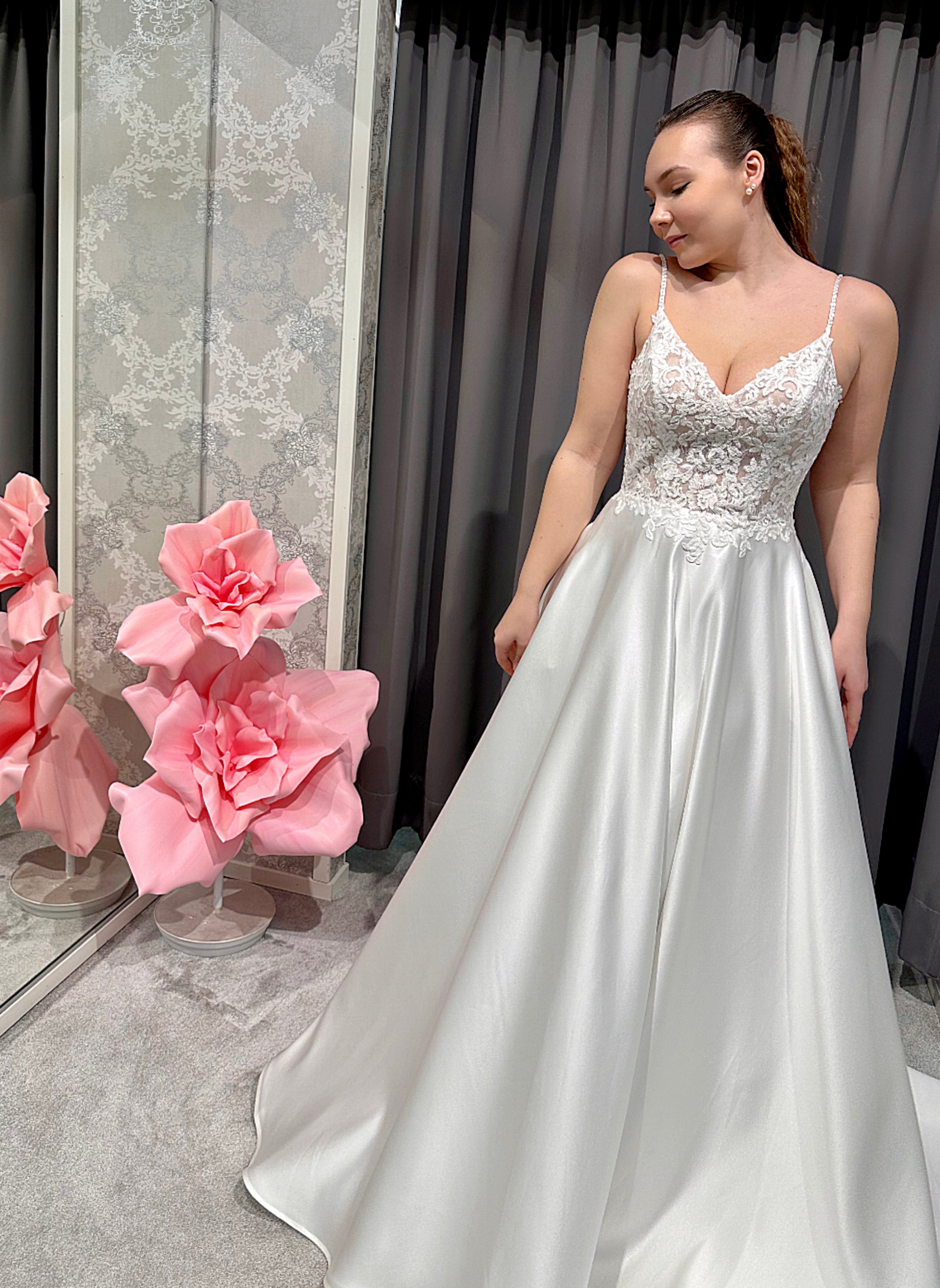 Häämekko, jossa kirjailtu pitsiyläosa, sirot olkaimet ja linjakas satiinihelma, etukuva.