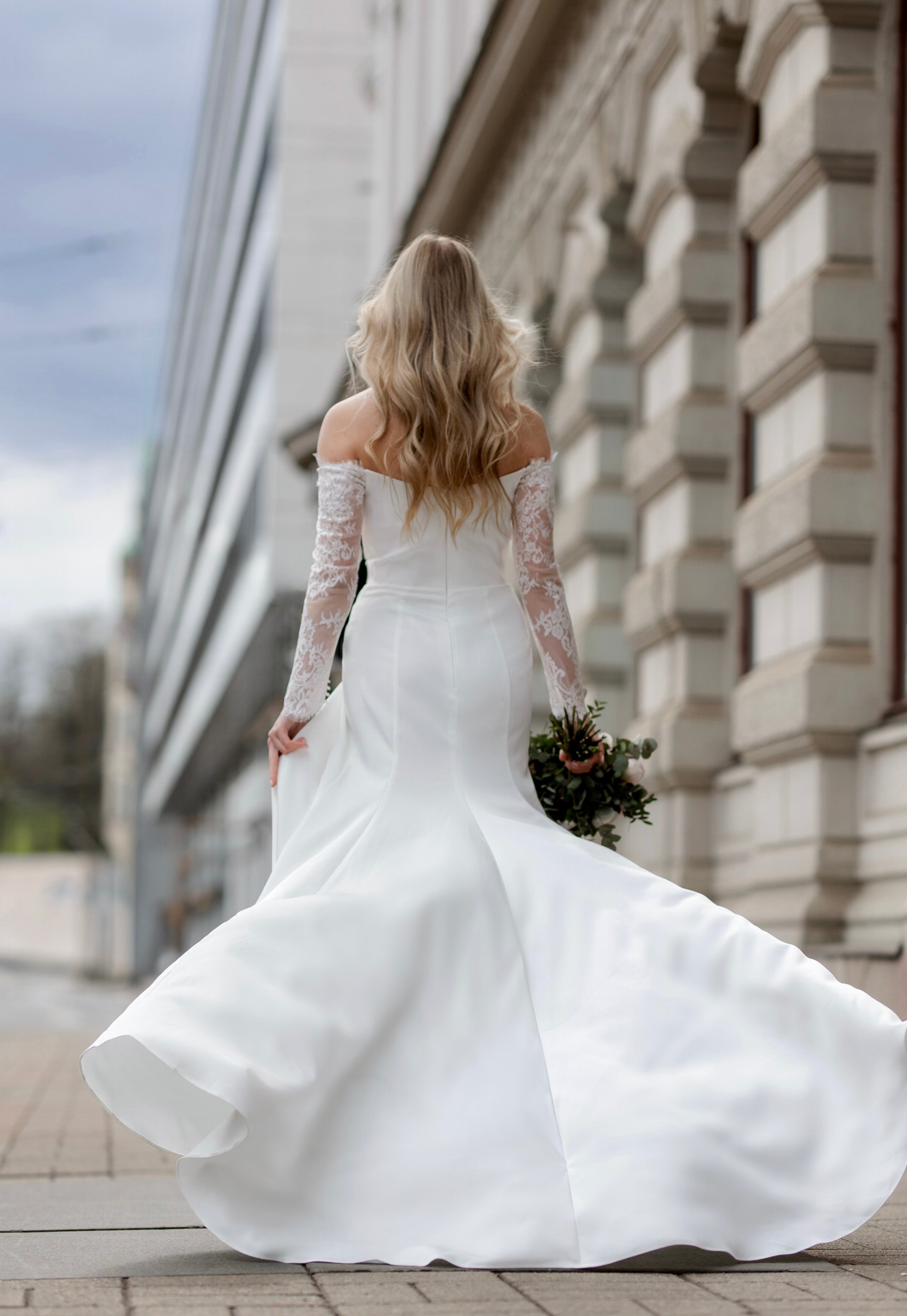 Häämekko Nina vartaloa myötäilevällä kankaalla, pitkä hiha ja sivuhalkio.