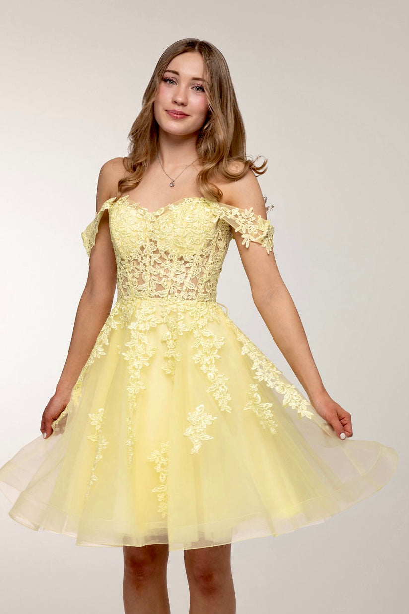 Upea keltainen juhlamekko tylli- ja pitsiyläosalla.