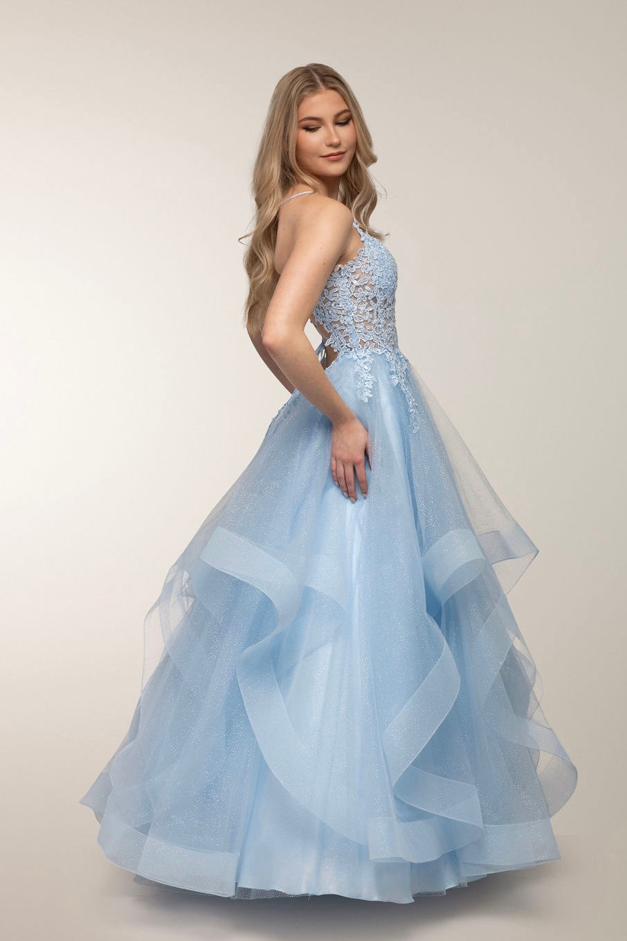 Vaaleansininen vanhojentanssimekko röyhelöhelmalla ja pitsiyläosalla, sivusta.