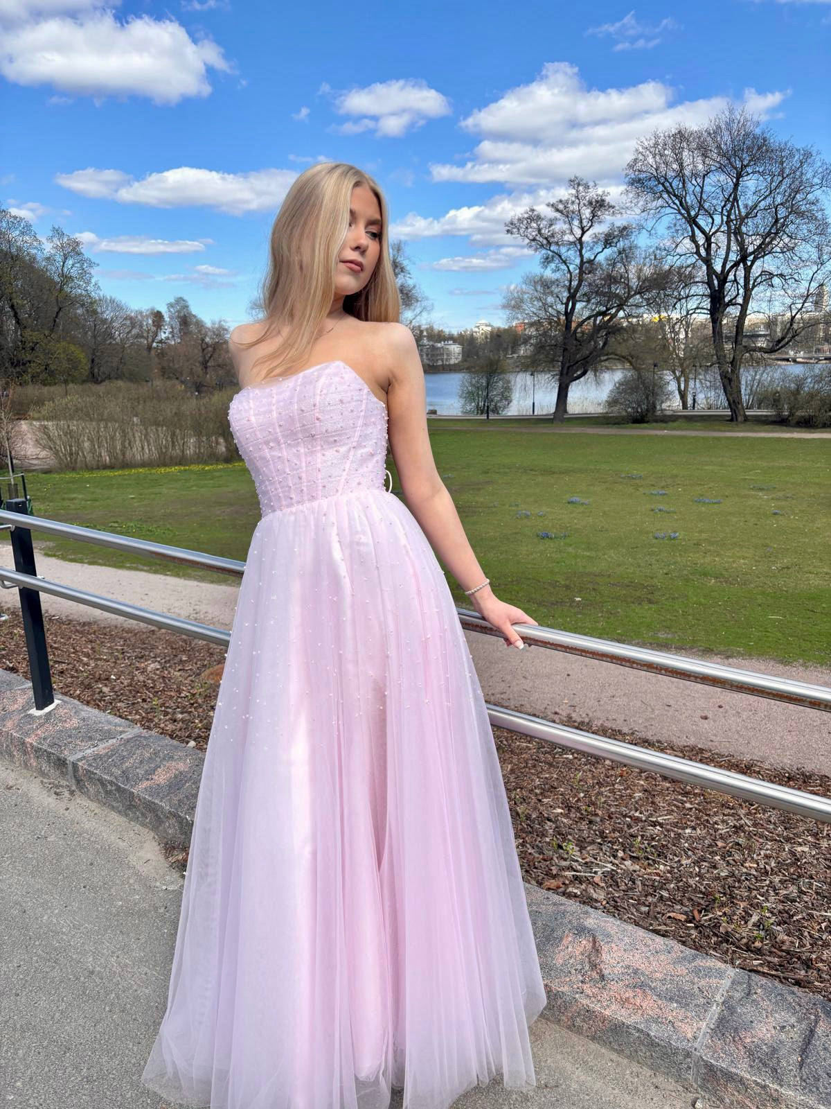 Olkaimeton vaaleanpunainen vanhojentanssimekko, edestä kuvattu.