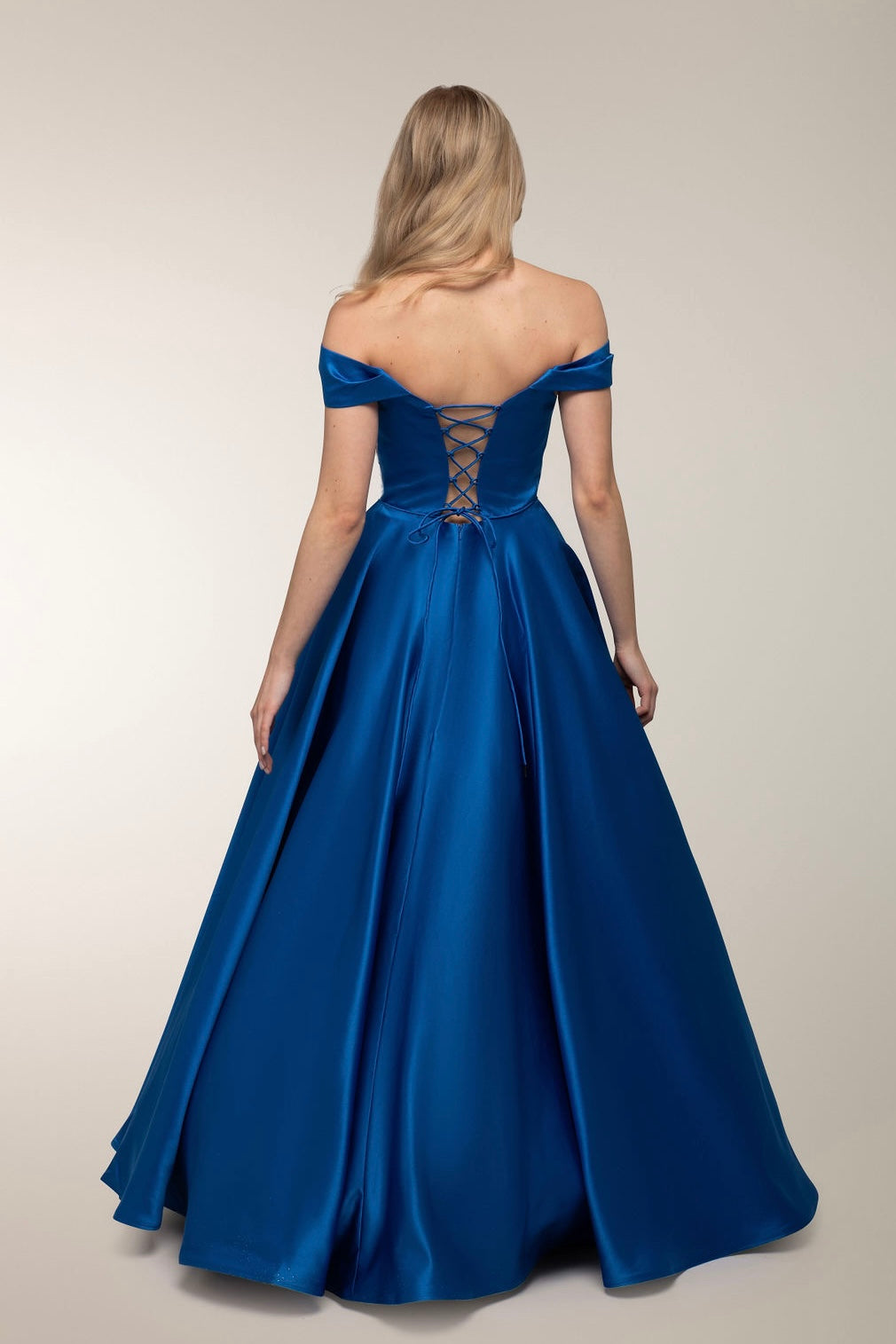 Kirkkaan sininen satiininen vanhojentanssimekko off-shoulder-mallilla, takaa.