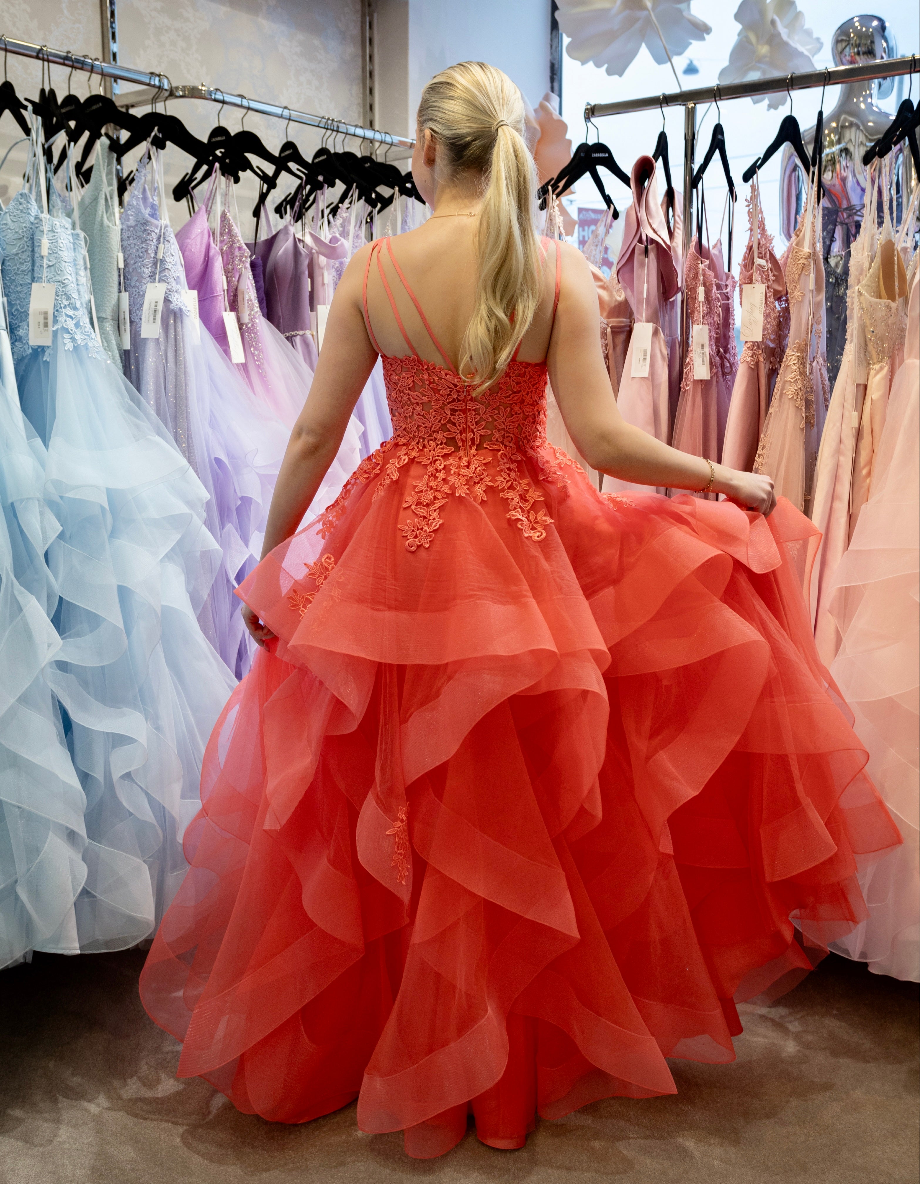 Oranssi vanhojentanssimekko pitsiyläosalla ja röyhelöhelmalla, takaa.