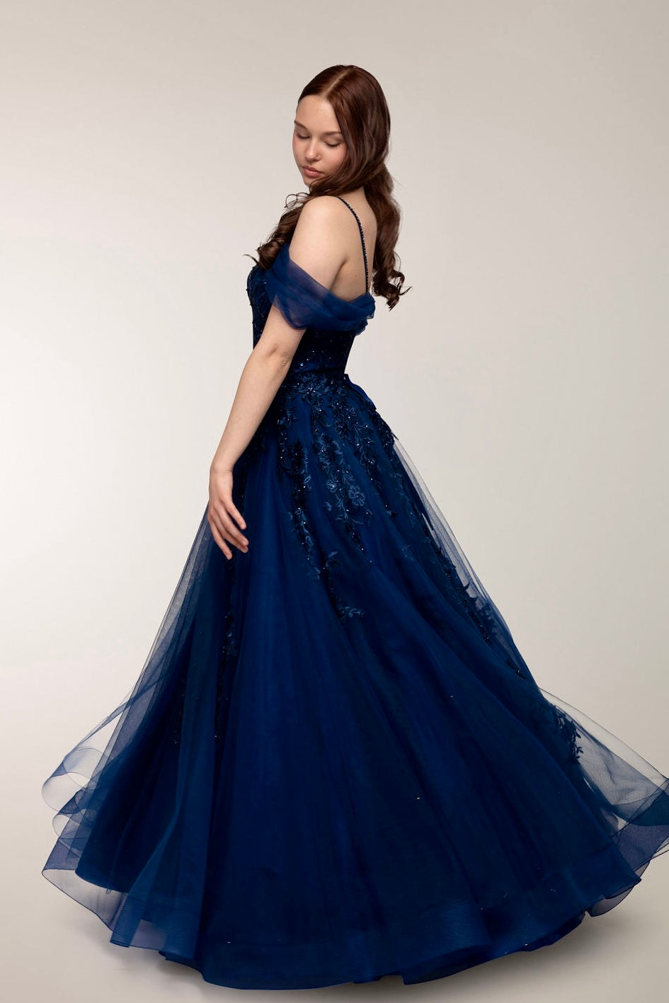 Tummansininen vanhojentanssimekko off shoulder -olkaimilla ja tyllihelmalla, sivusta.