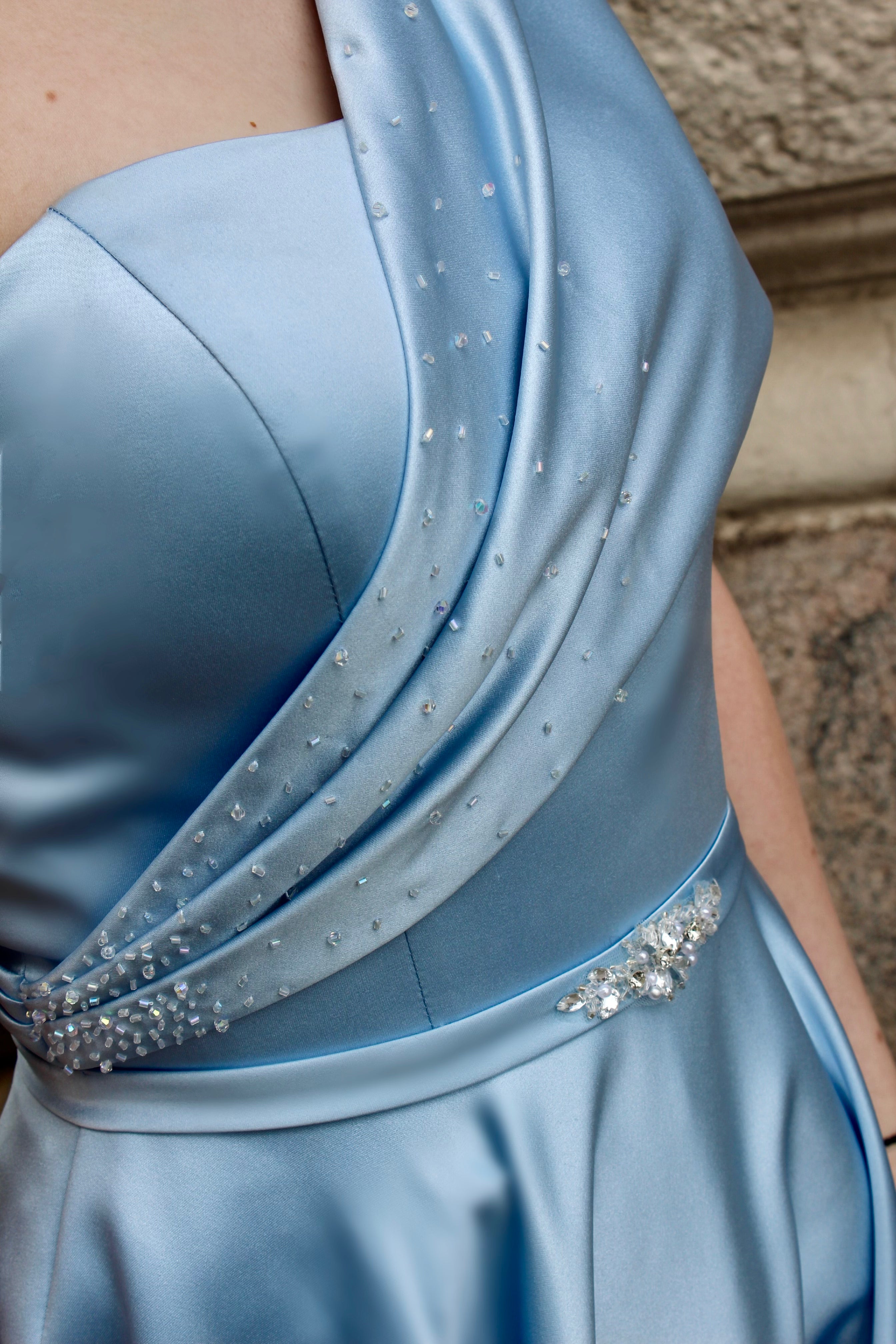 Vaaleansininen yksolkaiminen vanhojentanssimekko satiinista, lähikuva.