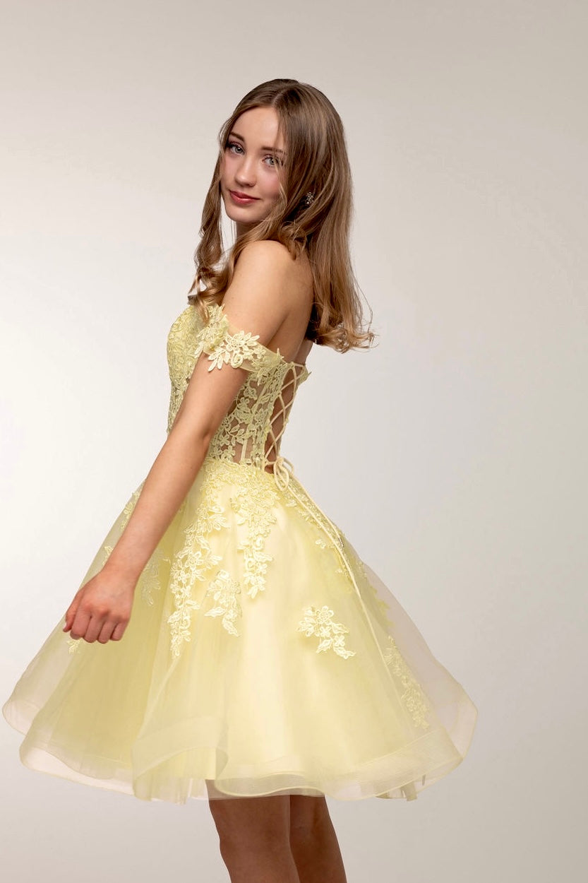 Upea keltainen juhlamekko tylli- ja pitsiyläosalla, sivusta.