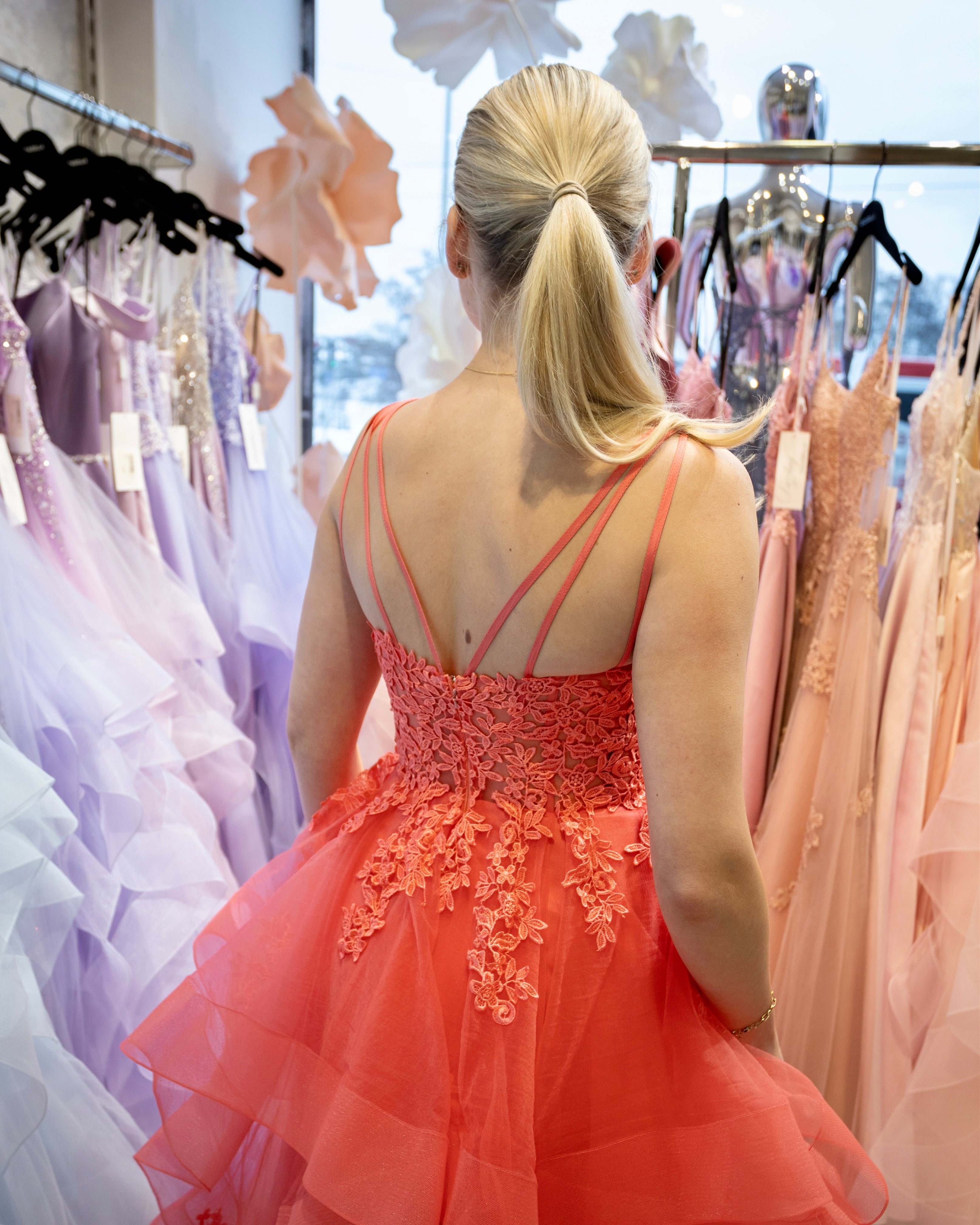 Oranssi vanhojentanssimekko pitsiyläosalla ja röyhelöhelmalla, takaa.