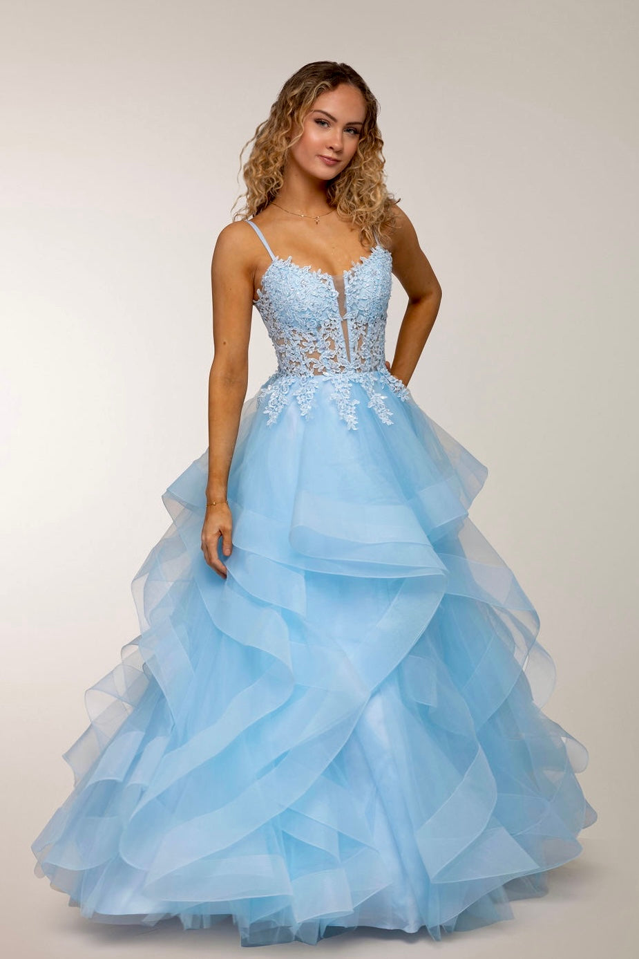 Vaaleansininen vanhojentanssimekko pitsiyläosalla ja röyhelöhelmalla, ilmava ja elegantti, edestä.