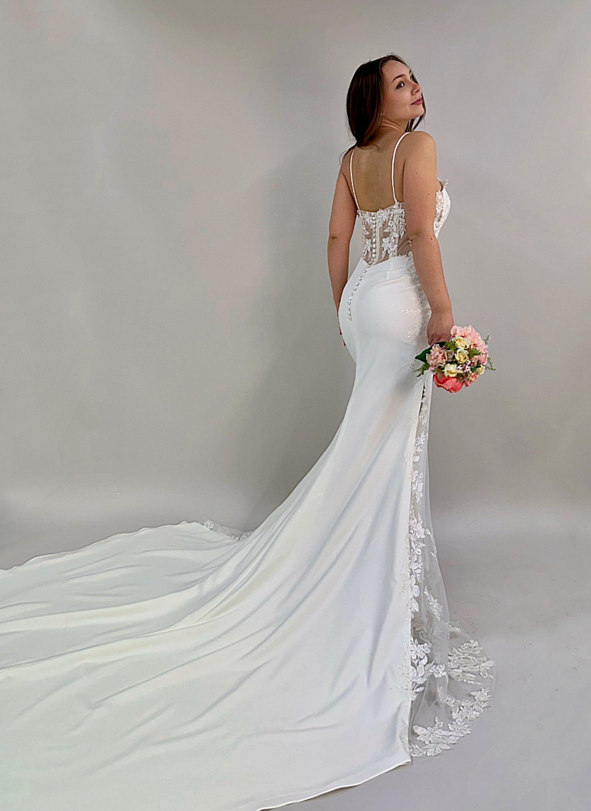 Häämekko tyköistuvalla merenneitomallilla, korsettiyläosa ja kukkapitsiyksityiskohdat, takaa.