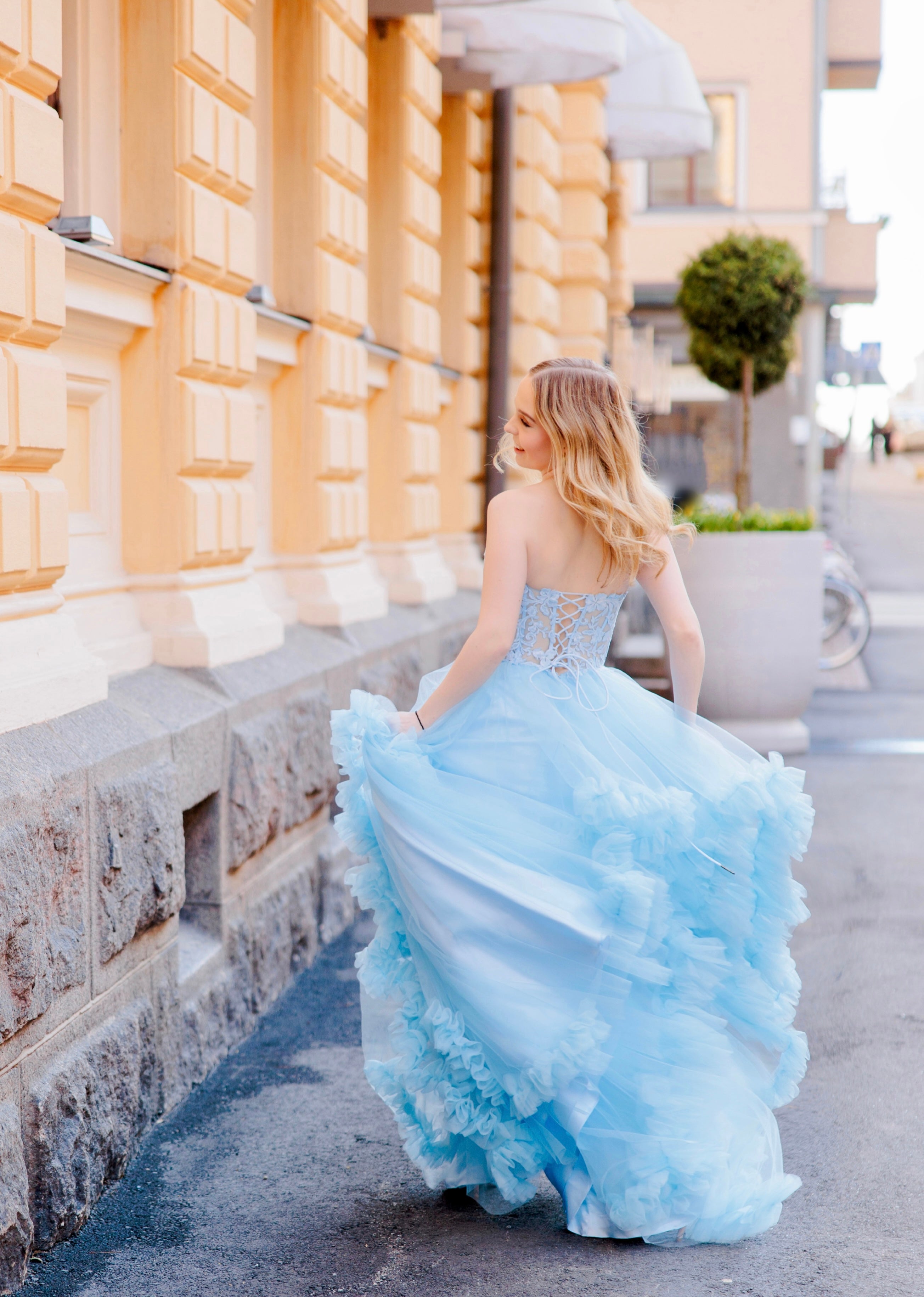 Olkaimeton vaaleansininen röyhelähelmainen vanhojentanssimekko, takaa.