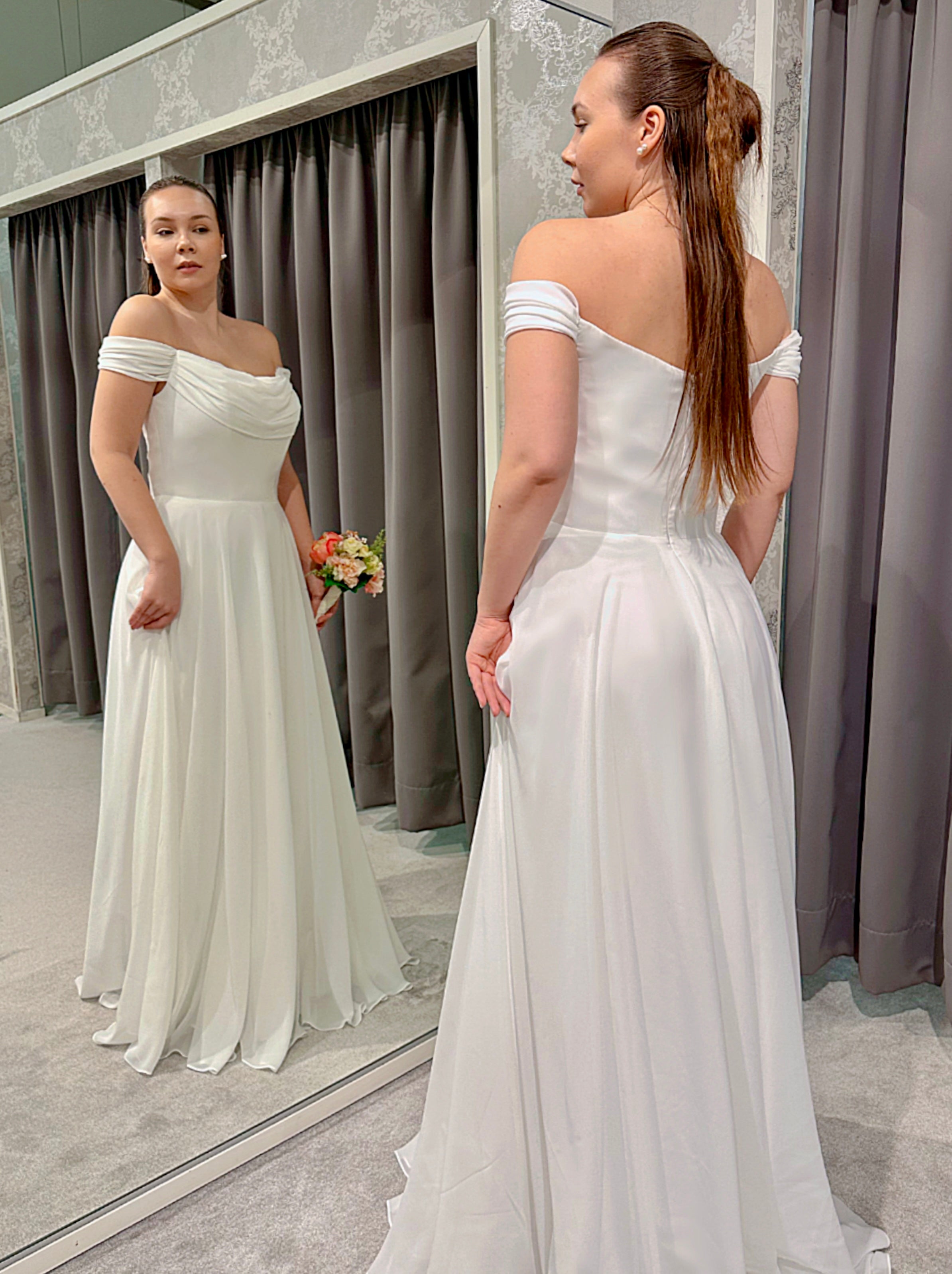 Klassinen häämekko laskostetulla yläosalla,elegantti ja romanttinen siluetti.