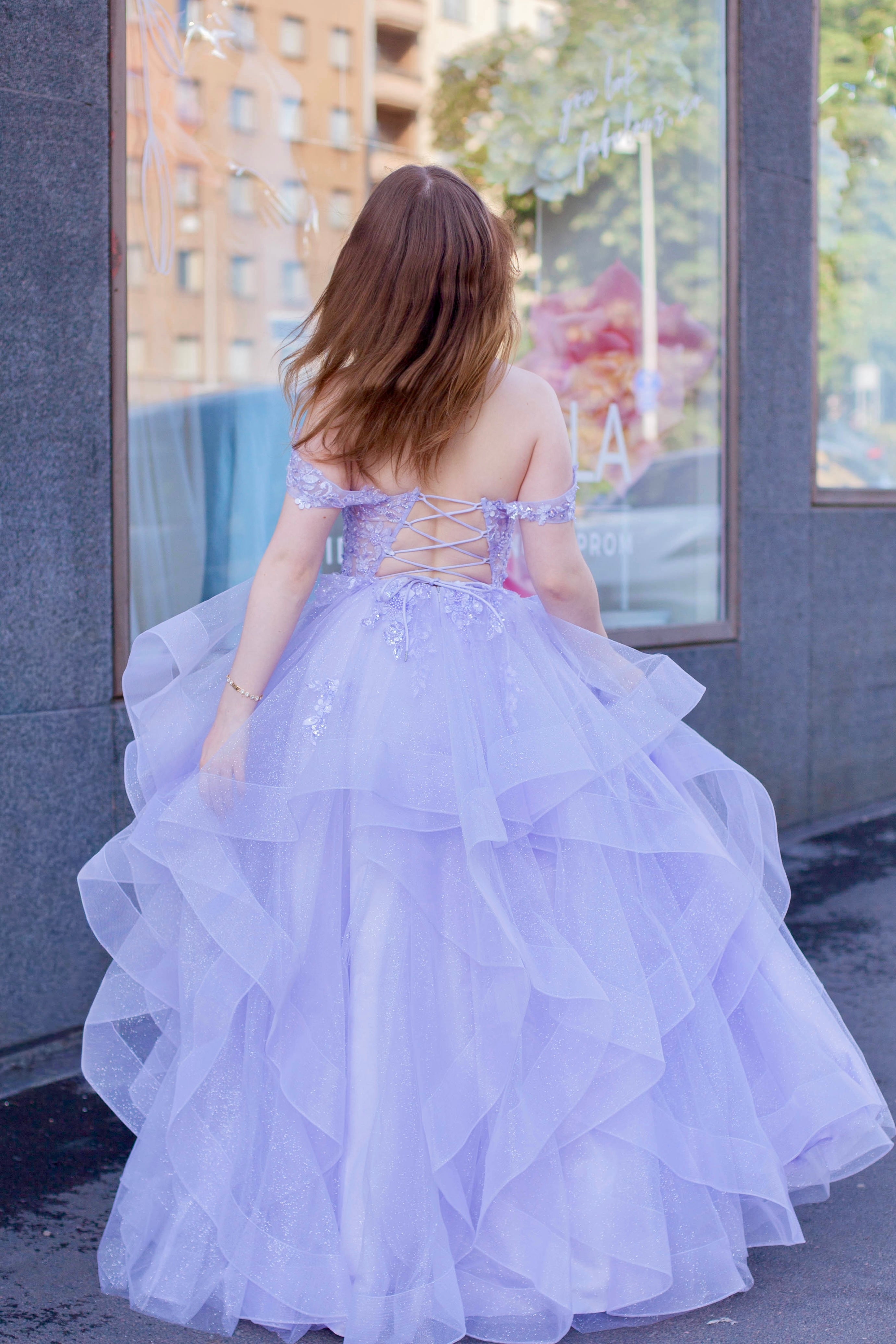 Violetti kimaltava vanhojentanssimekko off shoulder -yläosalla ja röyhelöhelmalla.