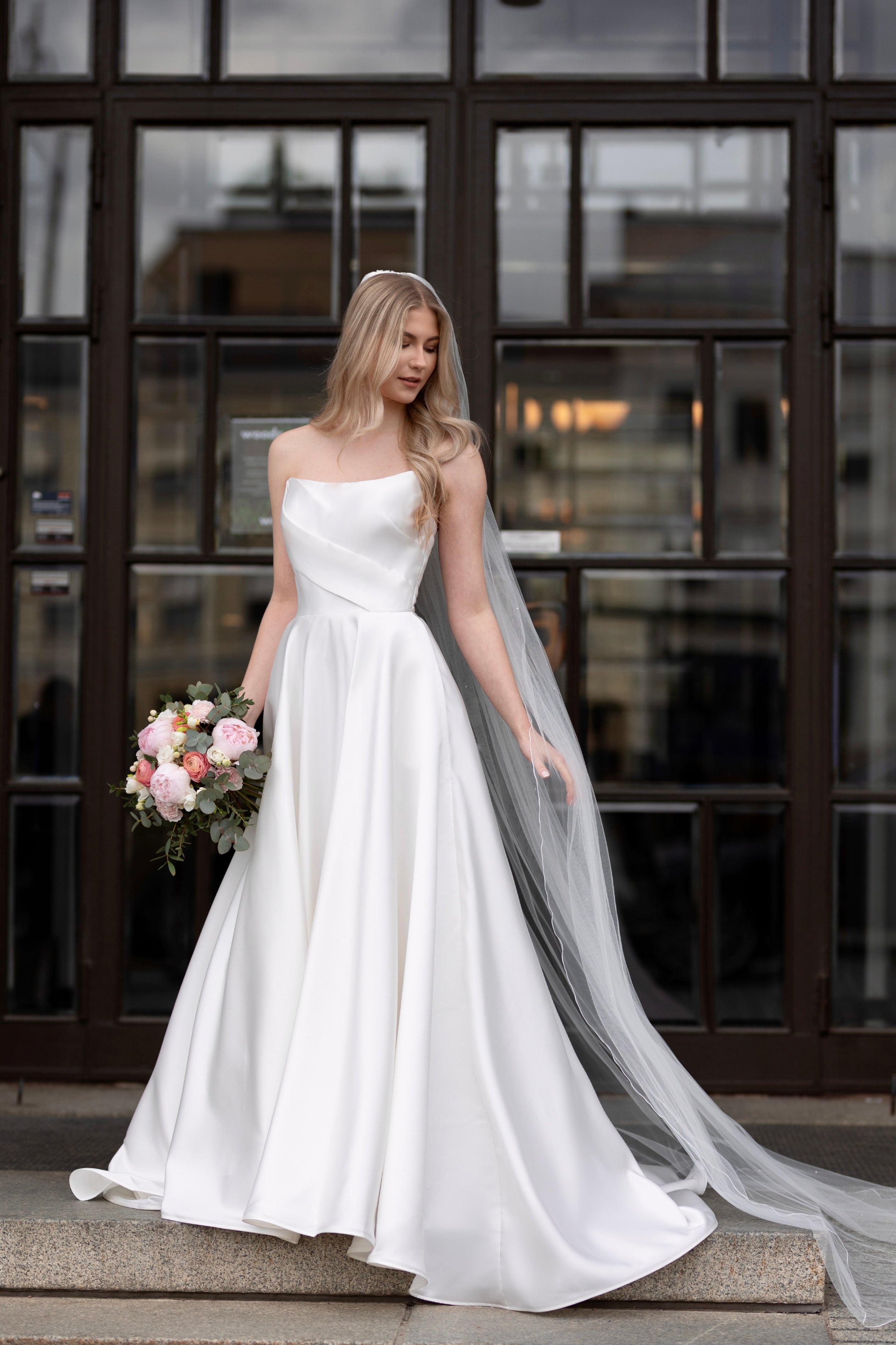 Olkaimeton satiininen häämekko klassisella A-linjaisella leikkauksella, edestä.