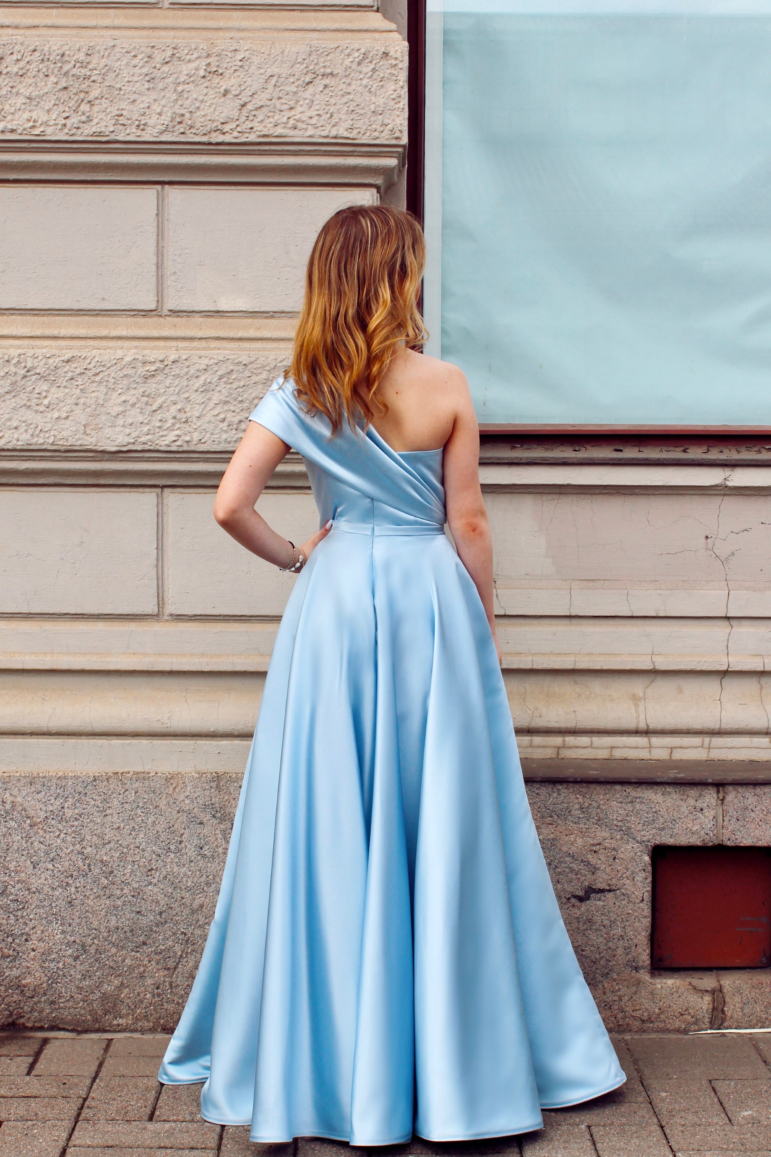 Vaaleansininen yksolkaiminen vanhojentanssimekko satiinista, takaa.