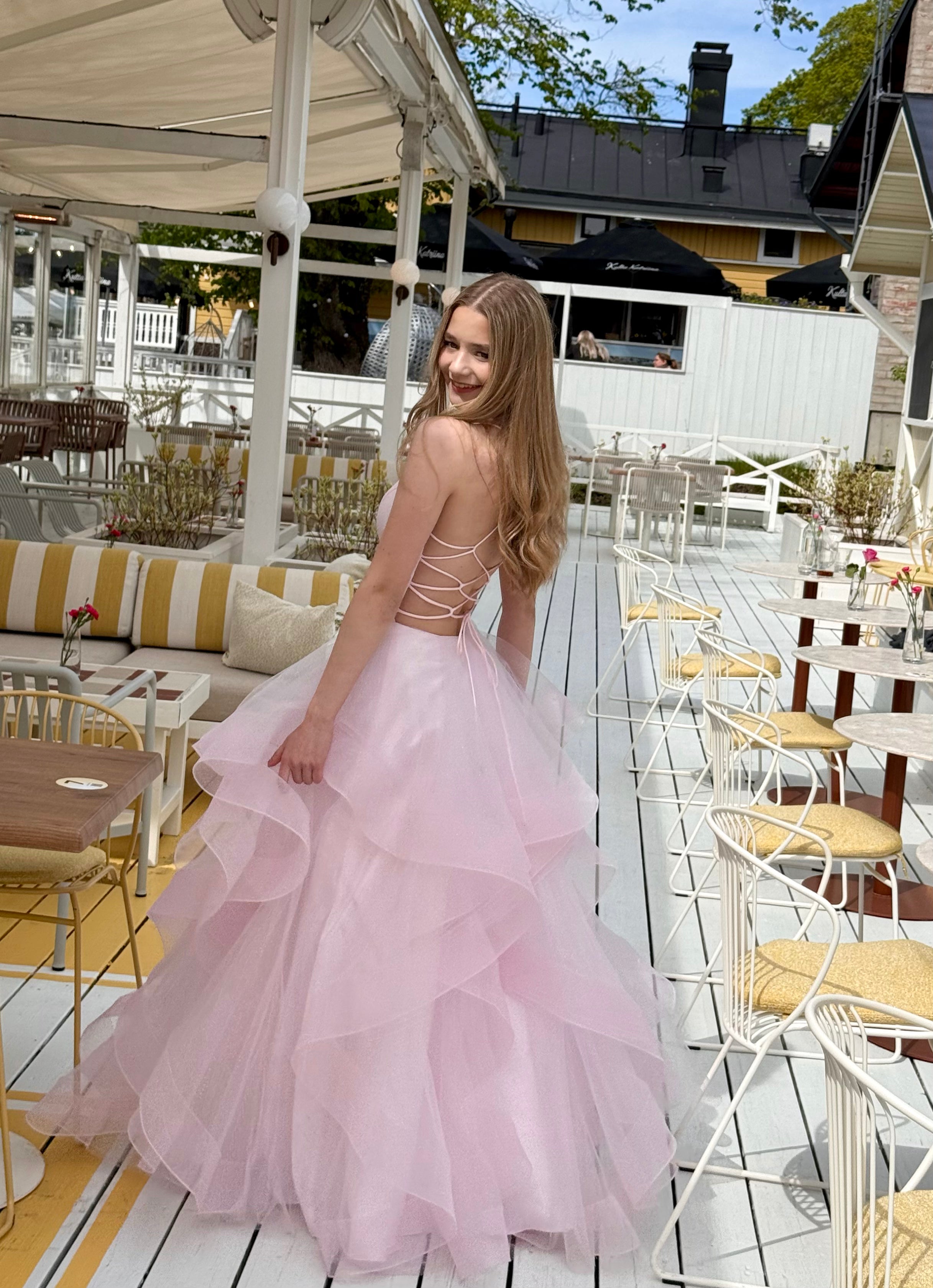 Pinkki röyhelöhelmainen vanhojentanssimekko, takaa kuvattu.