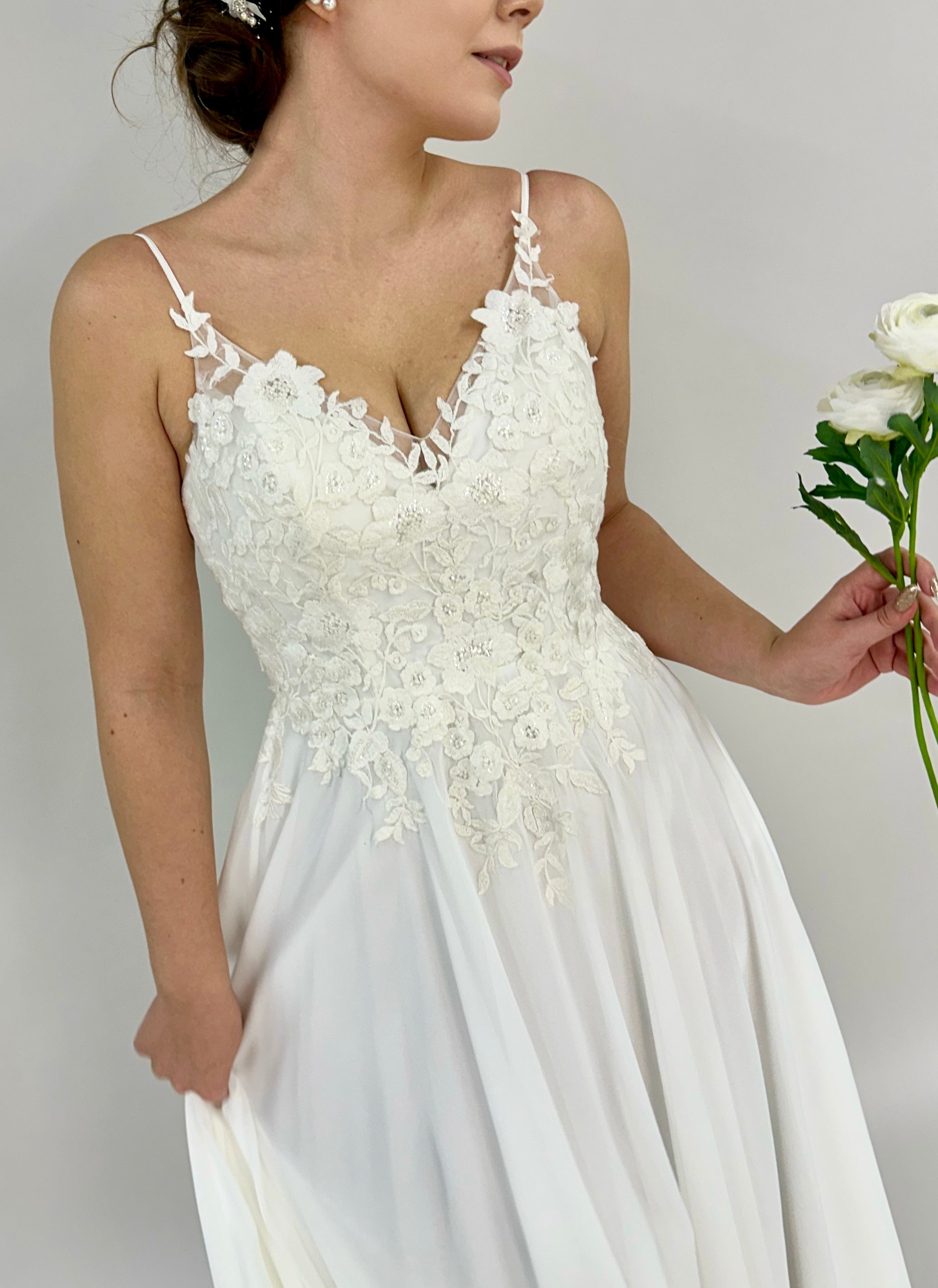 Sifonkinen häämekko pitsiyläosalla, ohut olkain ja avoin selkä, edestä.