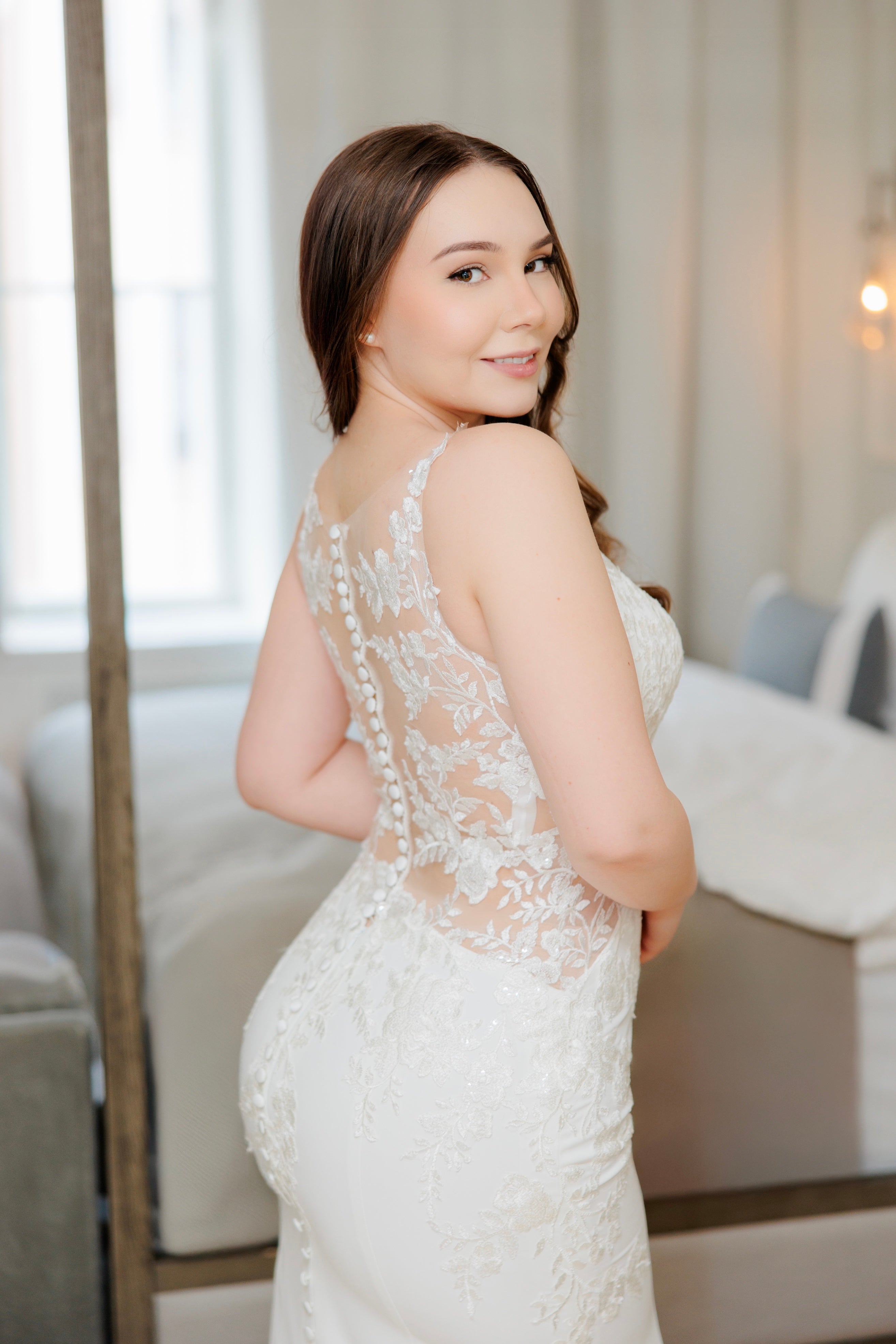 Tyköistuva häämekko pitsiselällä ja näyttävällä laahuksella, takakuva.