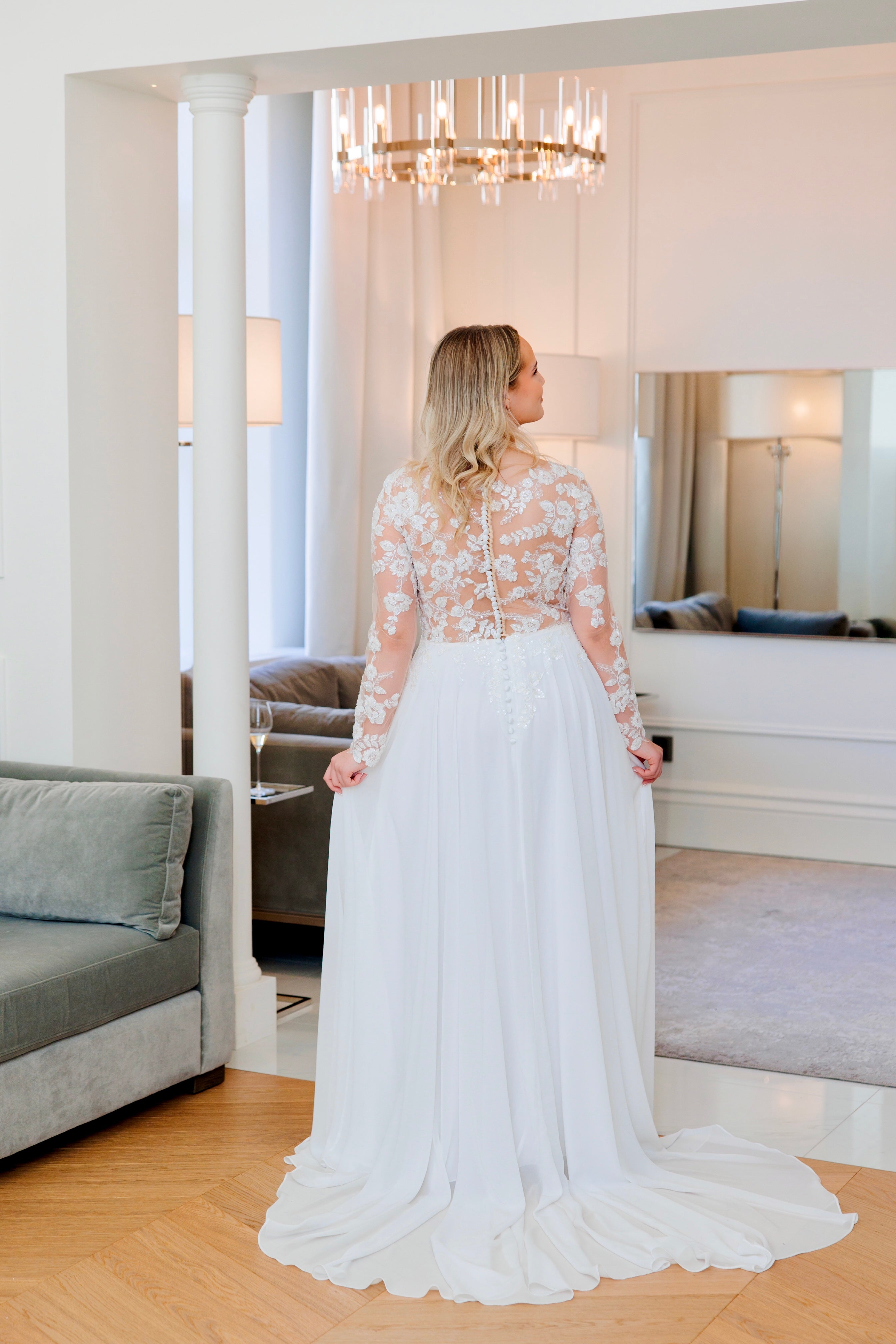 Häämekko pitsihihoilla, sifonkihelmalla ja kauniilla laahuksella, takakuva.