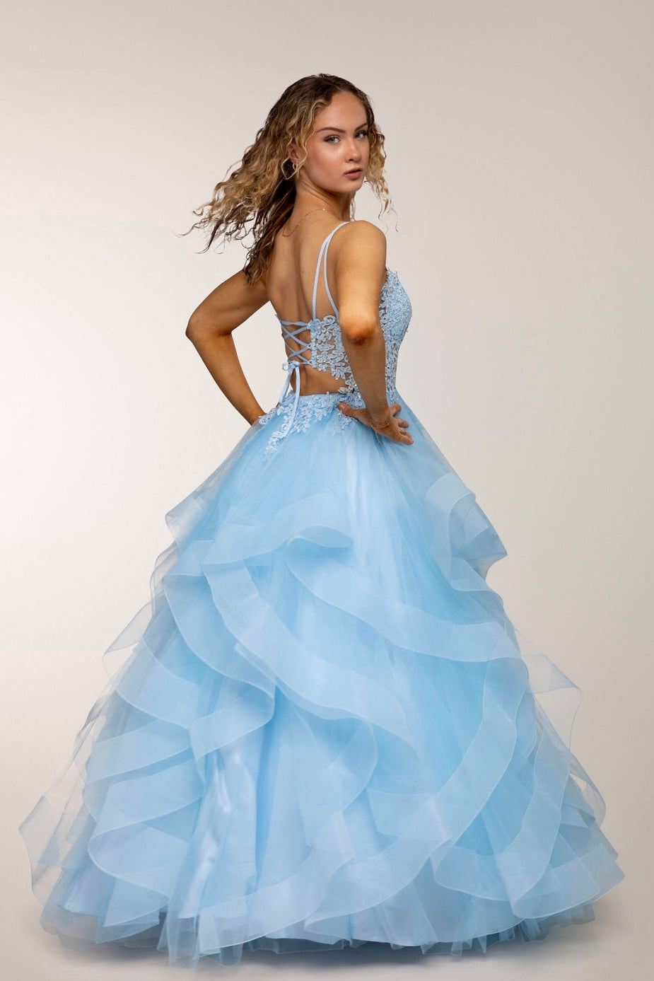 Vaaleansininen vanhojentanssimekko pitsiyläosalla ja röyhelöhelmalla, ilmava ja elegantti, selkä.