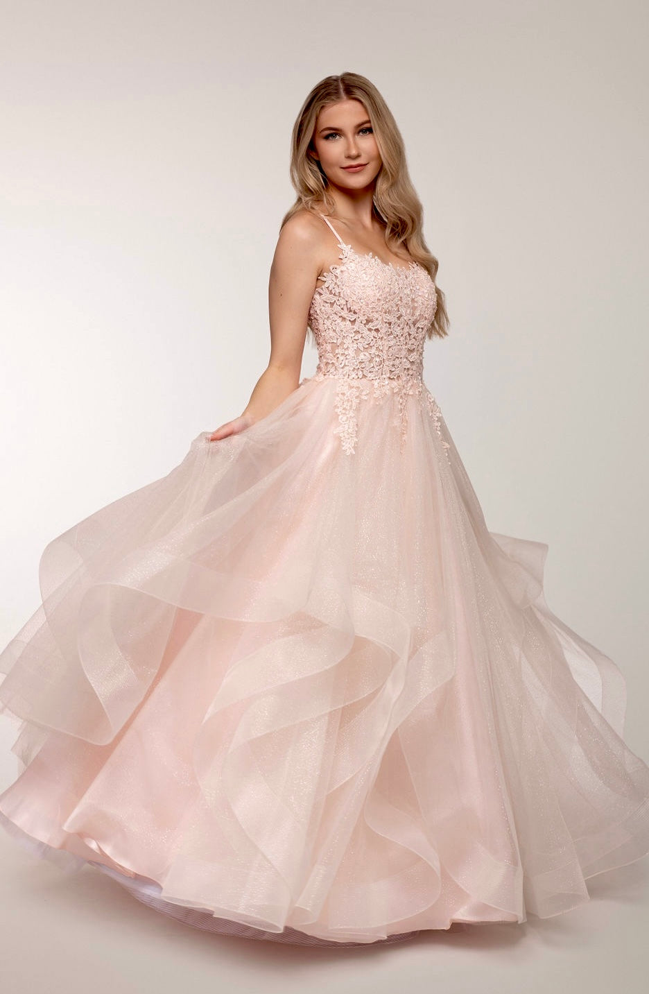 Vaaleanpunainen vanhojentanssimekko, röyhelöhelma, kimallus ja pitsikoristeinen yläosa, sivusta.