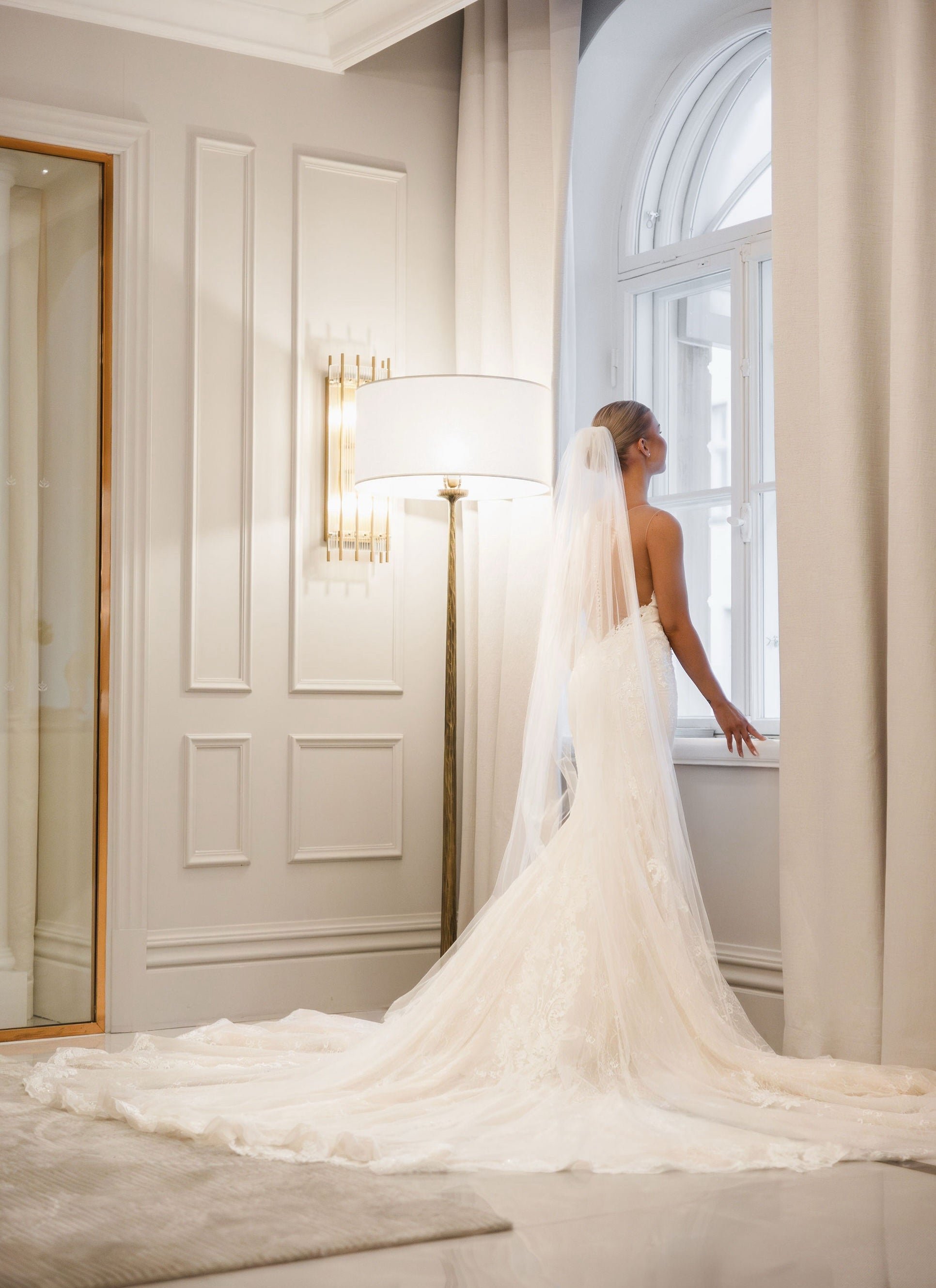 Tyköistuva häämekko pitsiyksityiskohdilla ja näyttävällä laahuksella, takakuva.