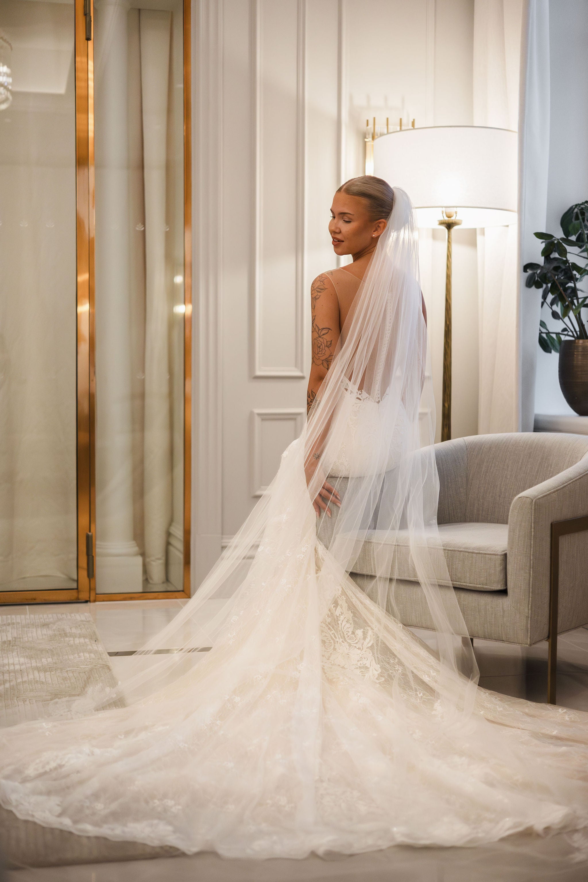 Tyköistuva häämekko pitsiyksityiskohdilla ja näyttävällä laahuksella.