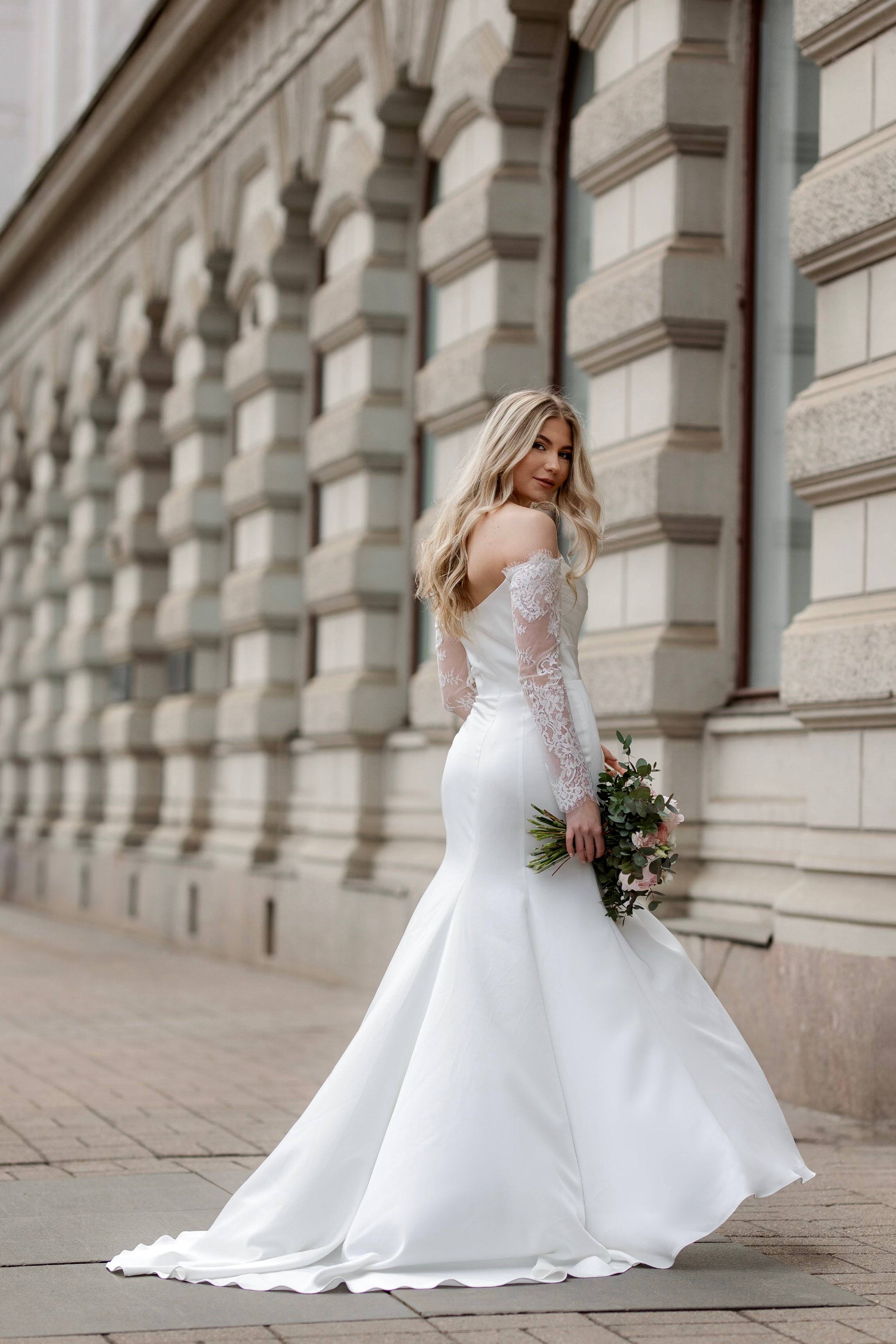 Häämekko Nina vartaloa myötäilevällä kankaalla, pitkä hiha ja sivuhalkio, takaa.