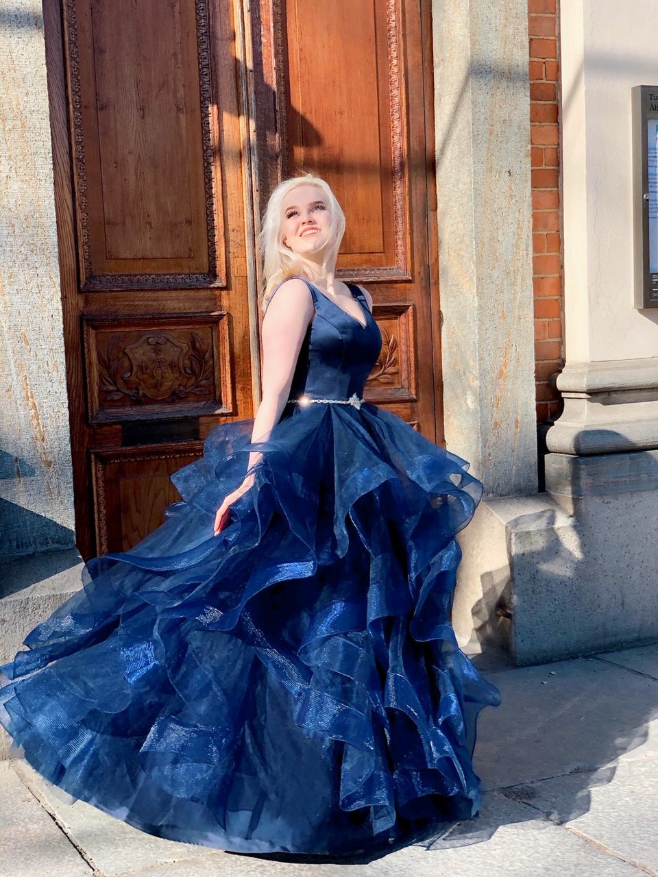 Tummansininen vanhojentanssimekko röyhelöhelmalla, sivusta.