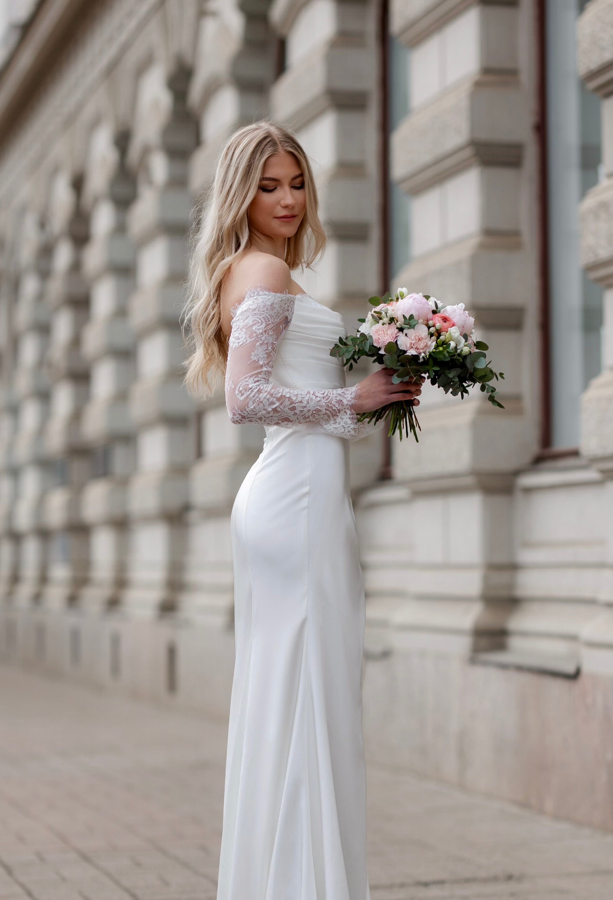 Häämekko Nina vartaloa myötäilevällä kankaalla, pitkä hiha ja sivuhalkio, sivusta.