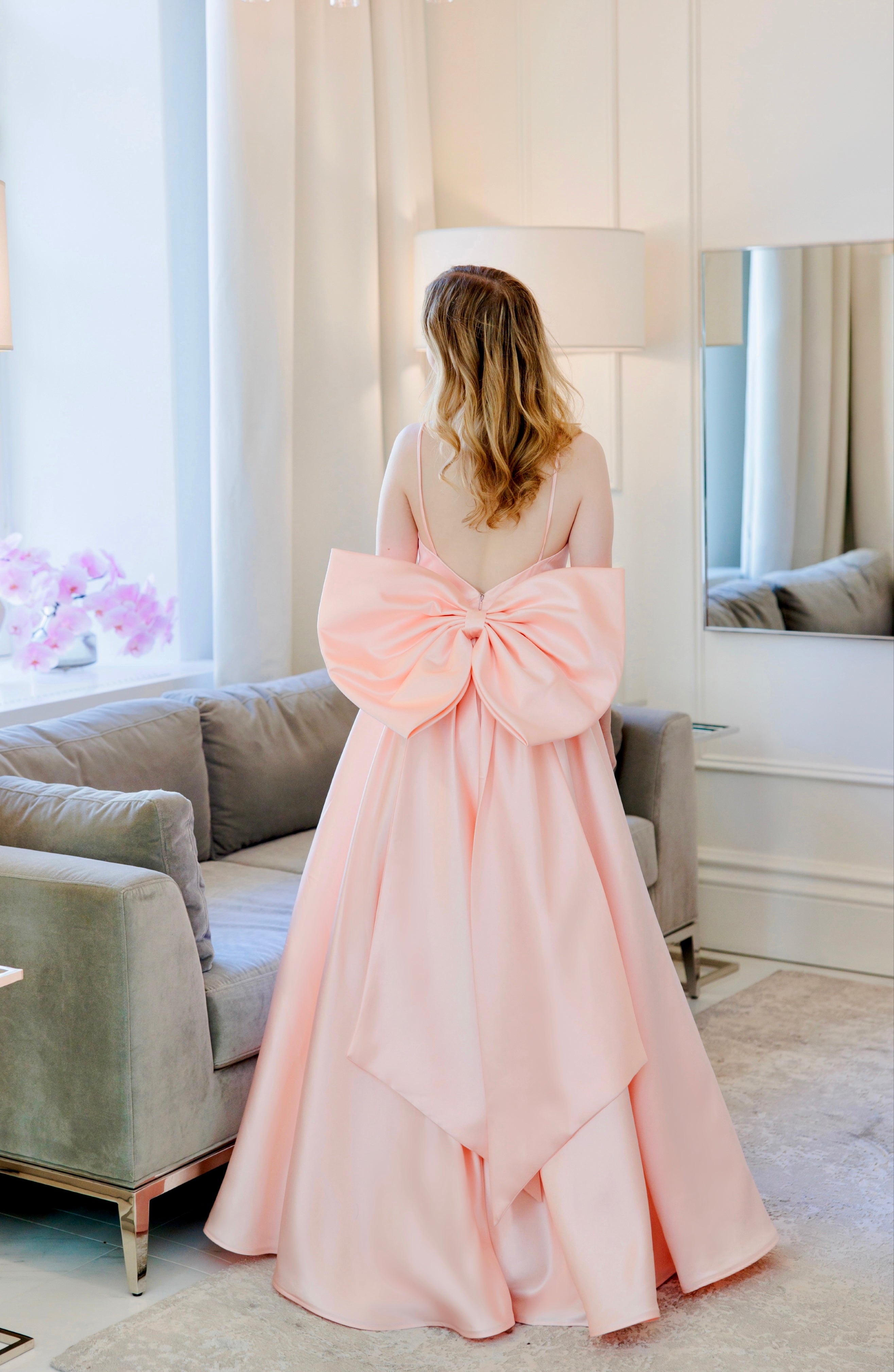 Vaaleanpunainen vanhojentanssimekko isolla rusetilla, takaa.