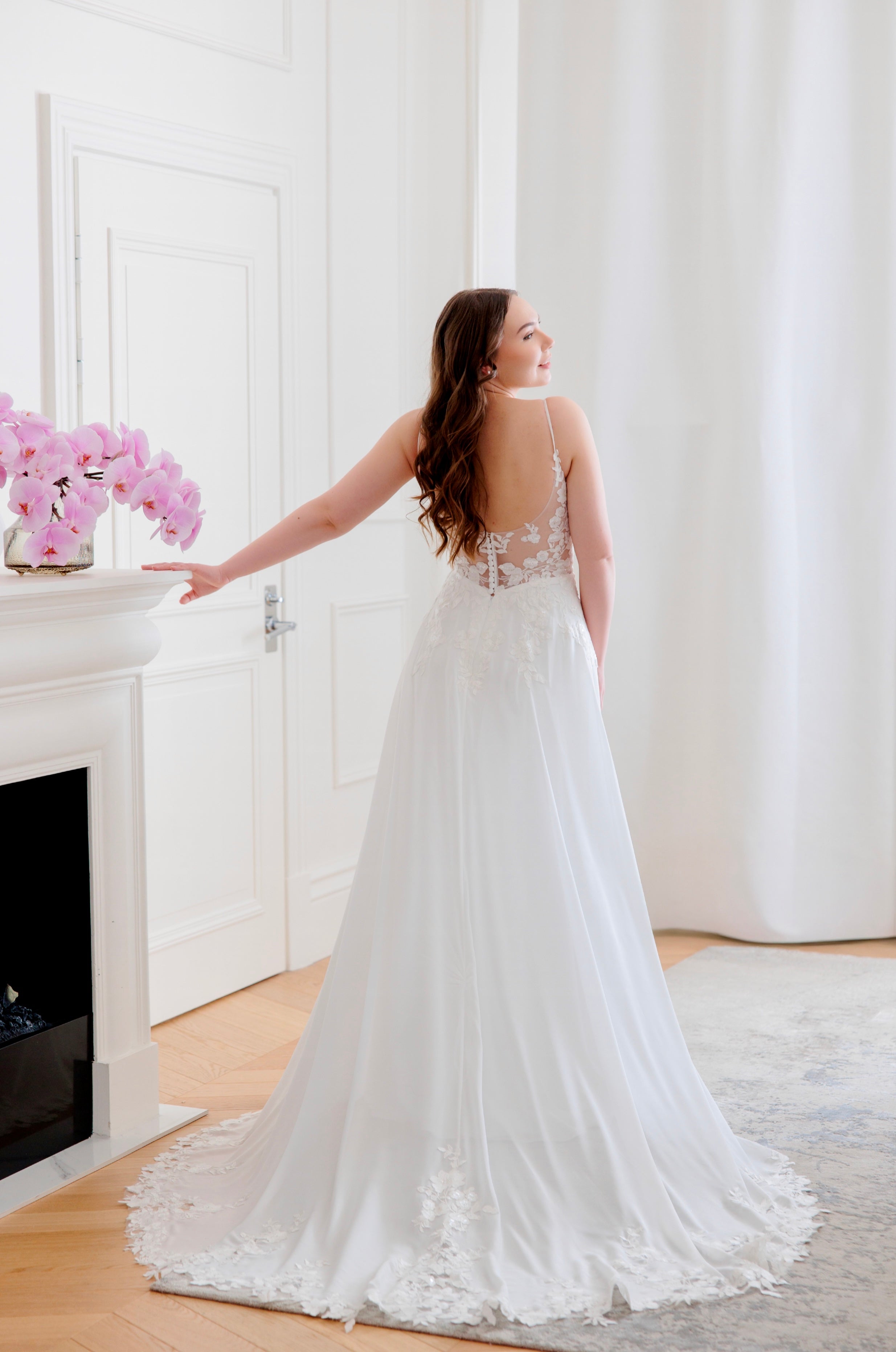 Häämekko sifongista, pitsiyksityiskohdilla ja näyttävällä laahuksella, takaa.