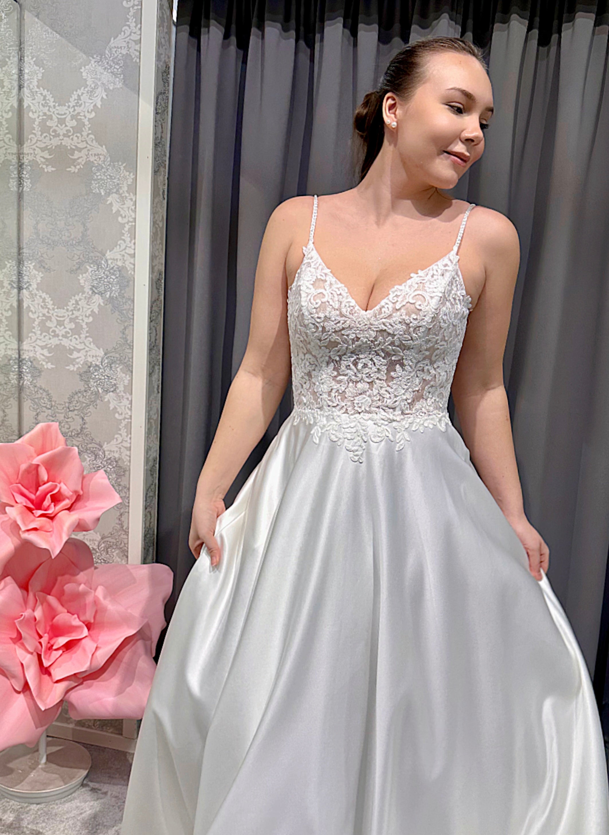 Häämekko, jossa kirjailtu pitsiyläosa, sirot olkaimet ja linjakas satiinihelma.