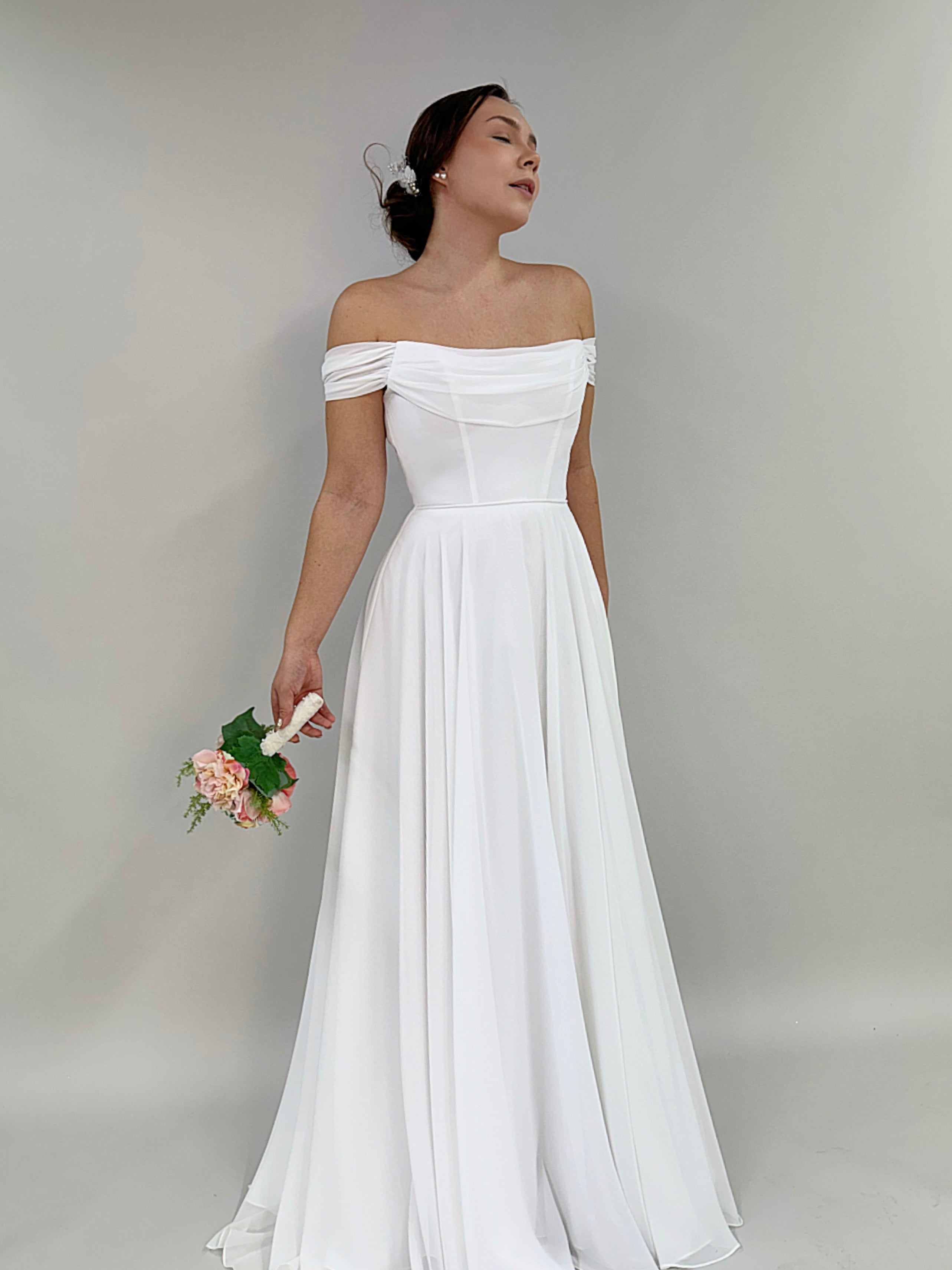 Klassinen häämekko laskostetulla yläosalla,elegantti ja romanttinen siluetti.