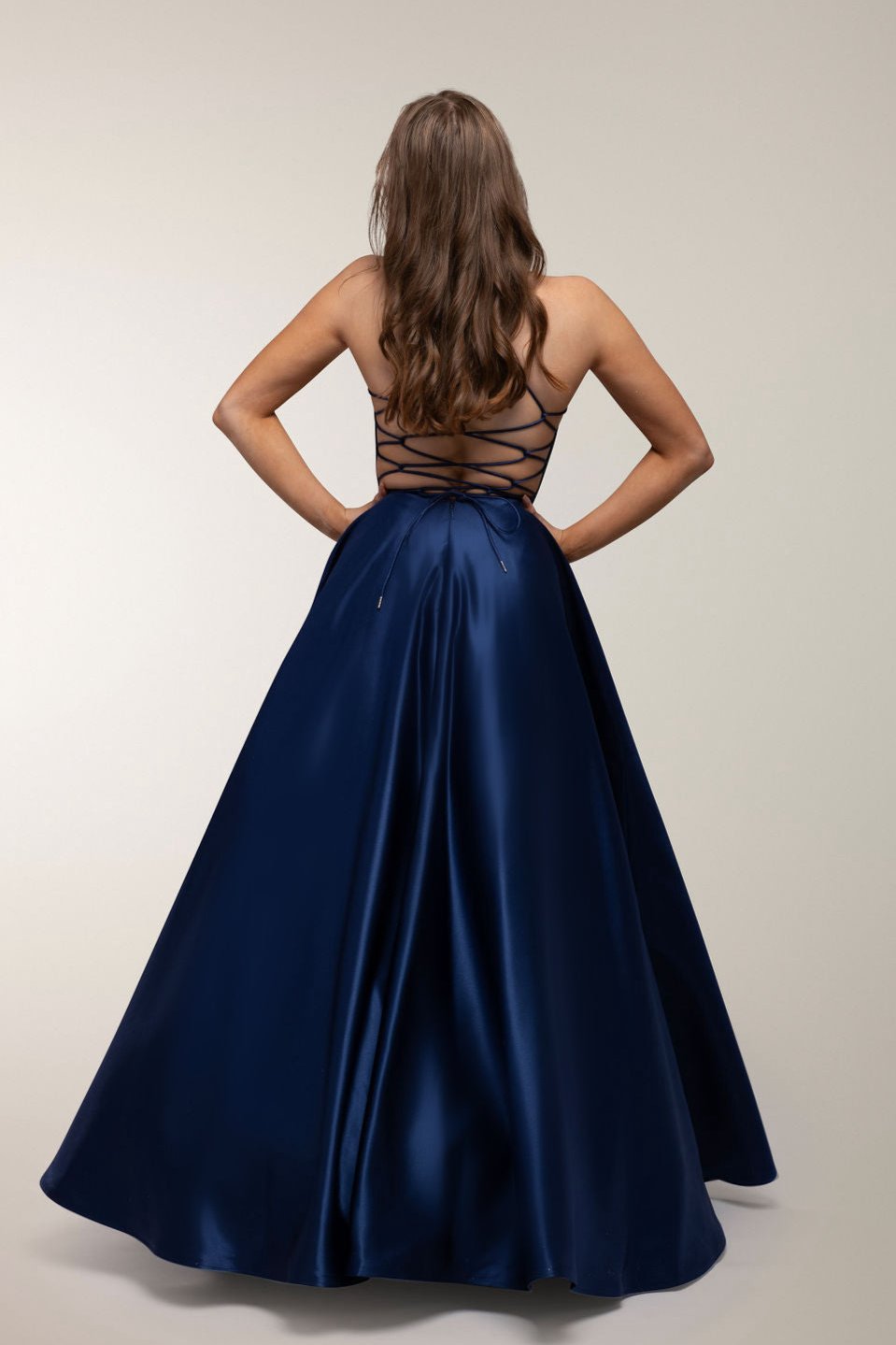 Tummansininen satiininen vanhojentanssimekko avoimella selällä, takaa.